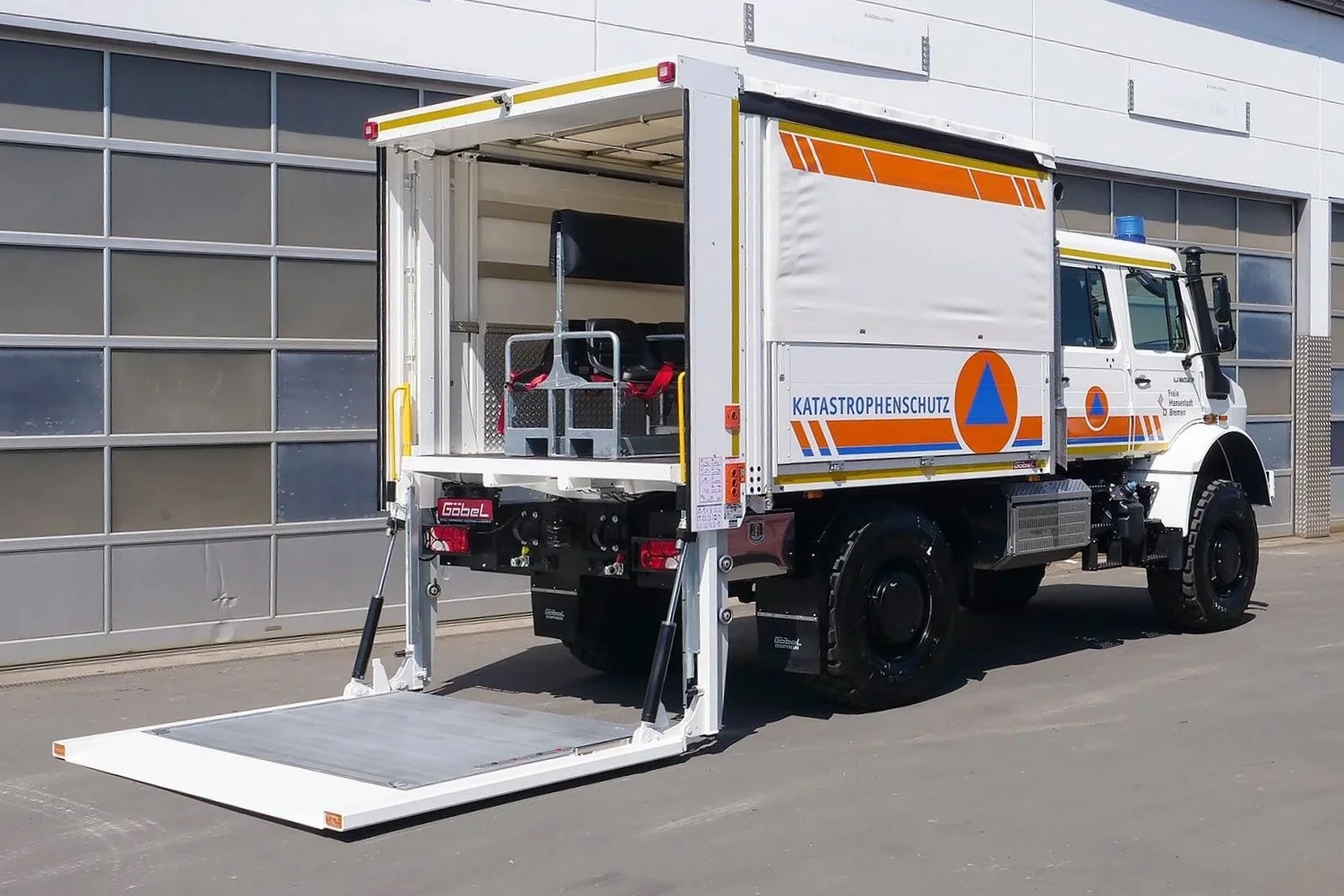 Gerätewagen Logistik Mercedes Benz Unimog für Katastrophenschutz Bremen aufgebaut von Göbel Fahrzeugbau, seitliche Heckansicht mit heruntergefahrenem Ladebordwand
