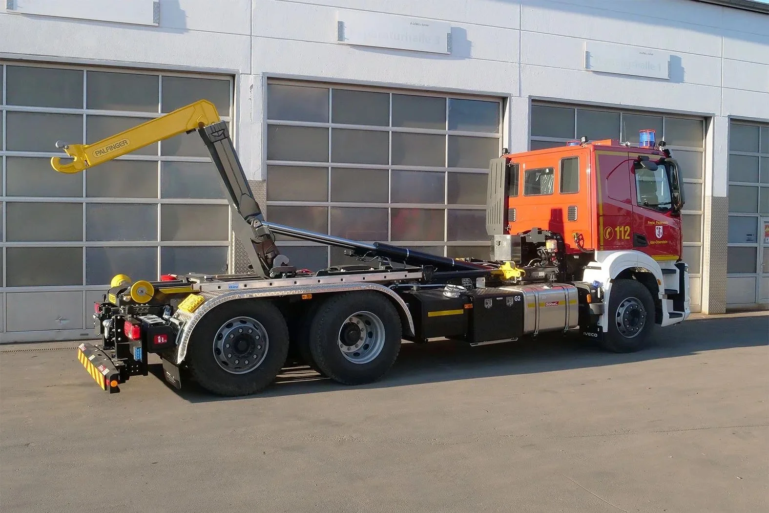 Wechselladerfahrzeug (WLF) aufgebaut IVECO LKW von Göbel Fahrzeugbau Heckansicht, mit ausgefahrenem Kran