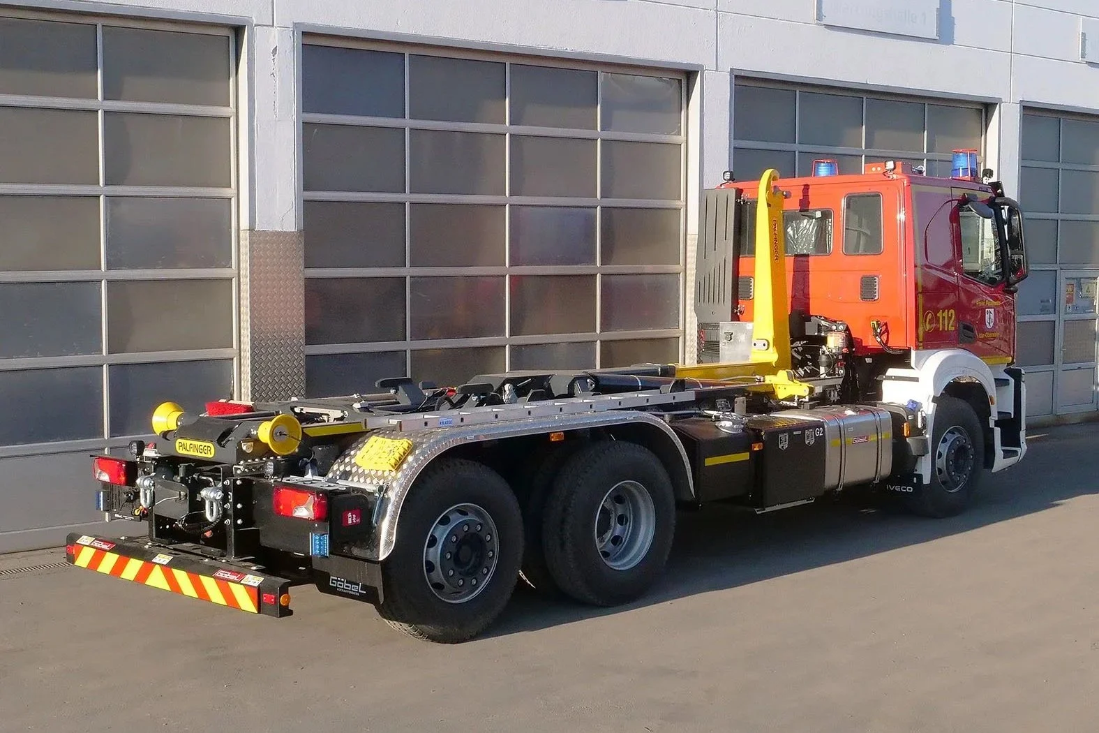 Wechselladerfahrzeug (WLF) aufgebaut IVECO LKW von Göbel Fahrzeugbau Heckansicht, mit eingefahrenem Kran