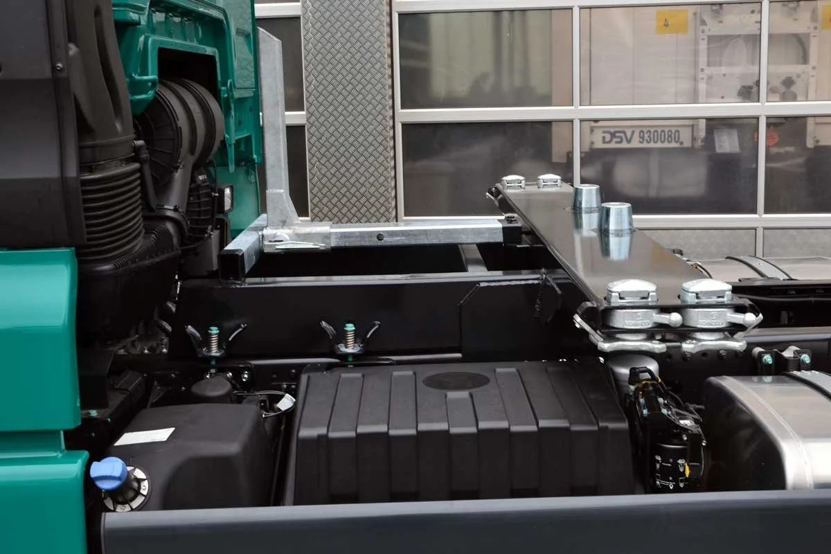 Nahaufnahme eines Fahrzeugmotors mit verschiedenen mechanischen Komponenten und Metallteilen.