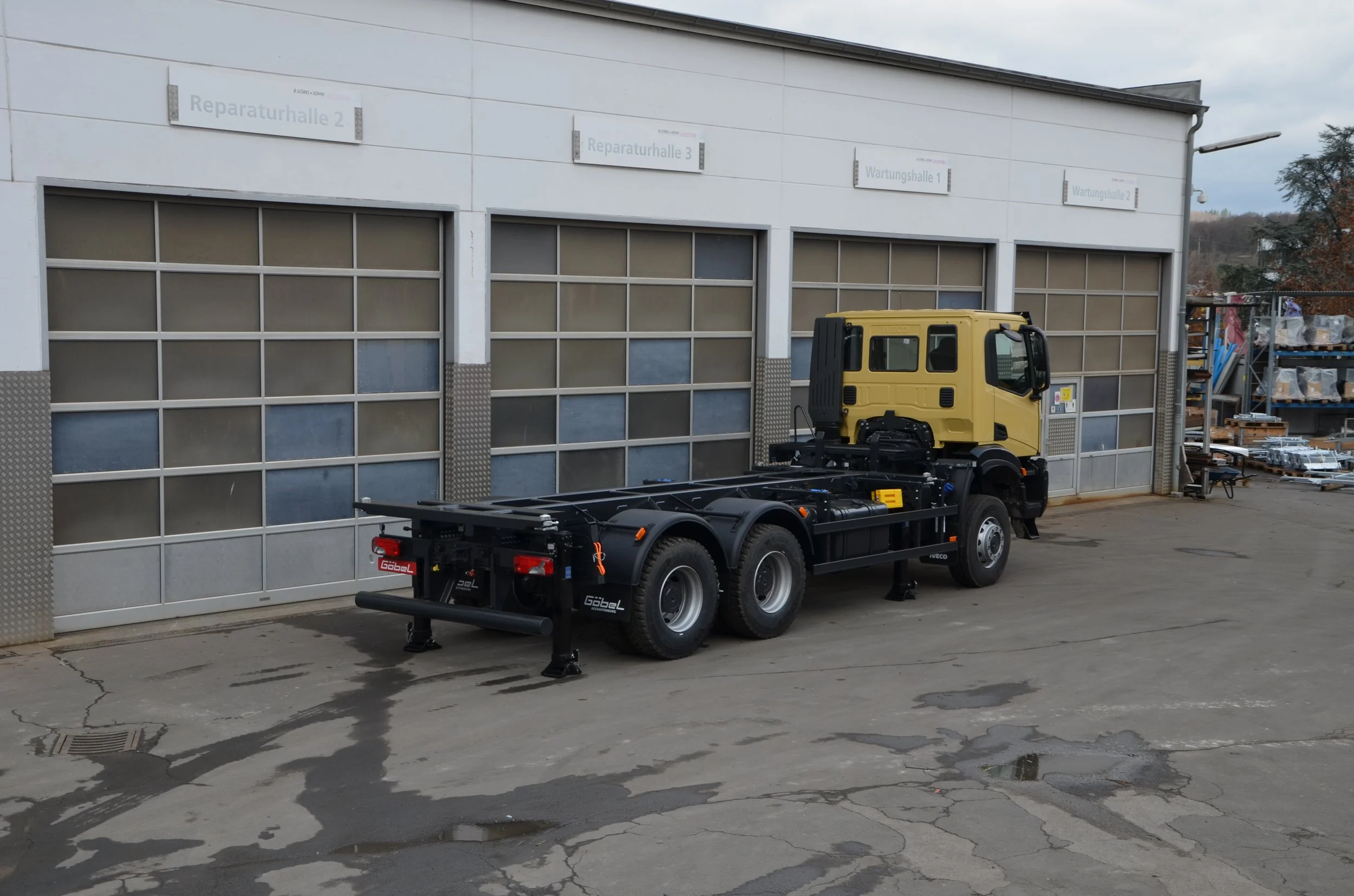 Gelber Iveco LKW aufgebaut von Göbel Fahrzeugbau als verwindungsarmer Transporter, seitliche Rückansicht