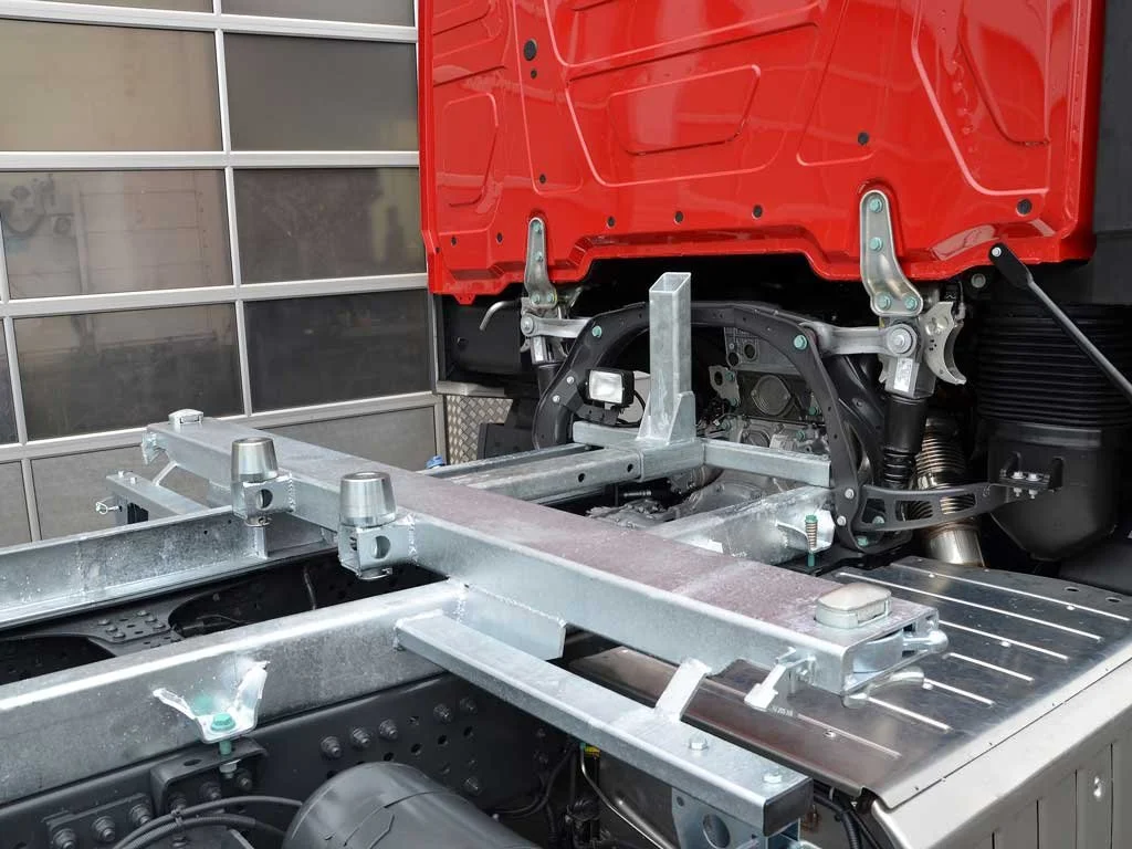 Blick auf die Innenseite einer umgebauten LKW-Fahrerkabine, die möglicherweise für den Einsatz als Bus oder spezieller Transporter vorbereitet wird, mit sichtbaren Metallrahmen und Fahrzeugkomponenten.