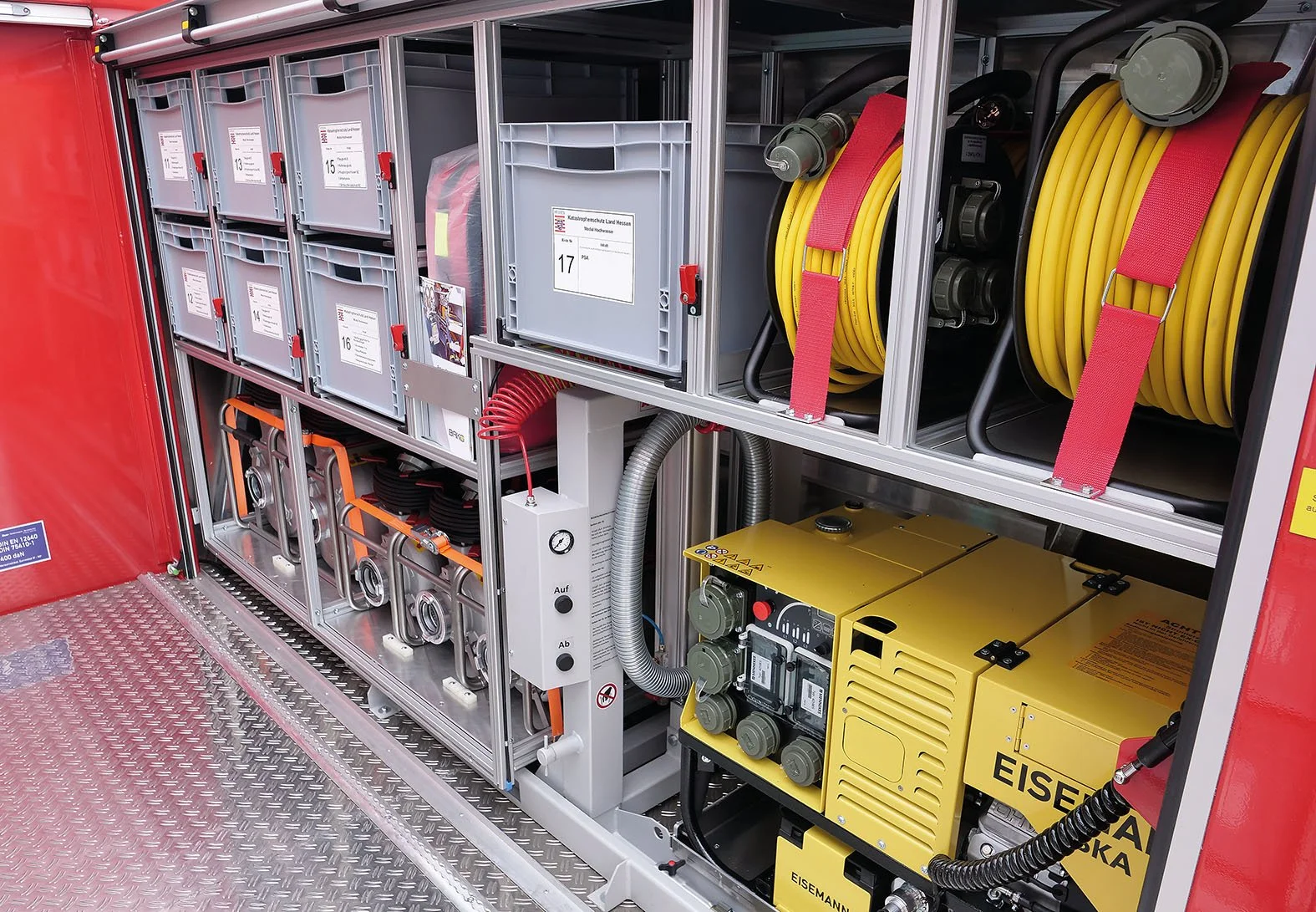 A close-up view of firefighting equipment inside a fire truck, including hoses, toolboxes, and control panels.