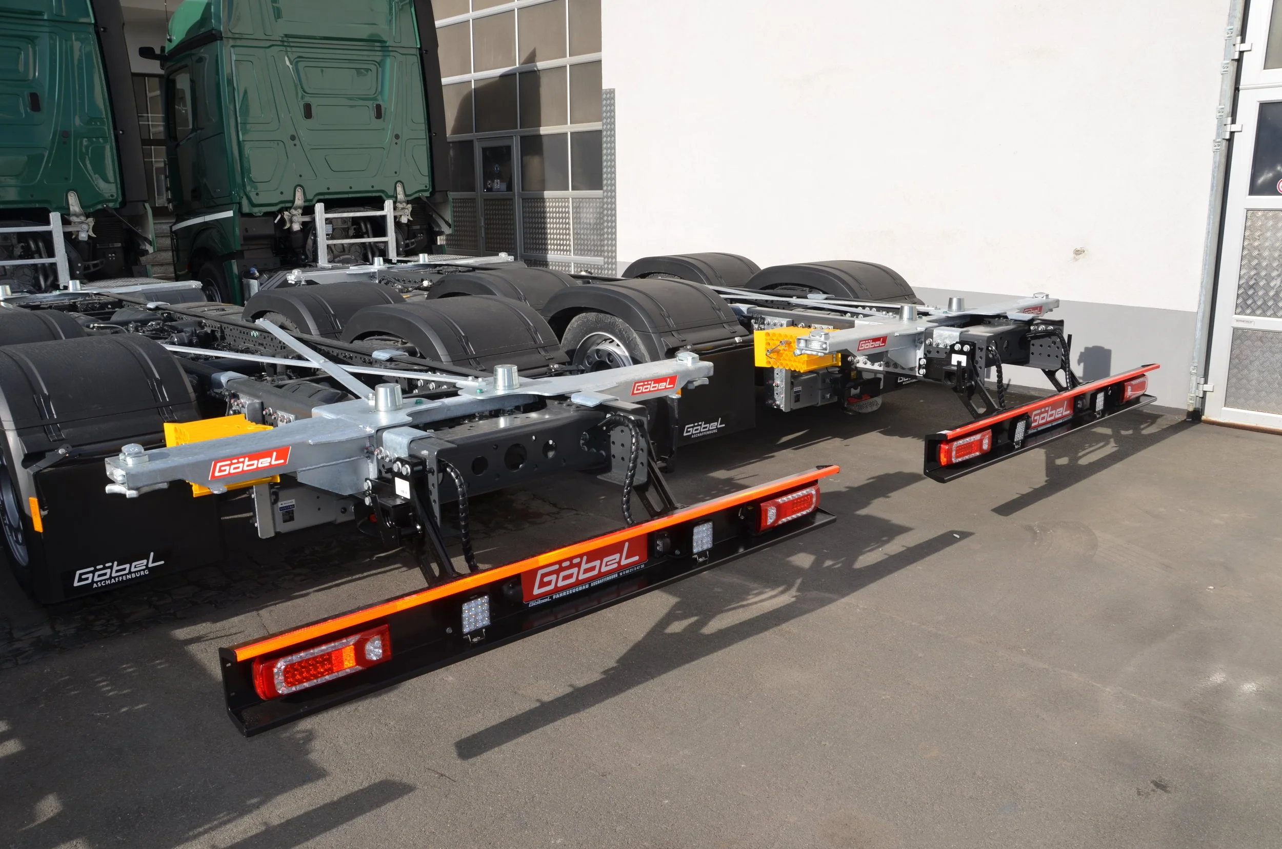 Leeres Autotransporter mit zwei Lkw-Fahrgestellen, die auf dem Anhänger stehen.