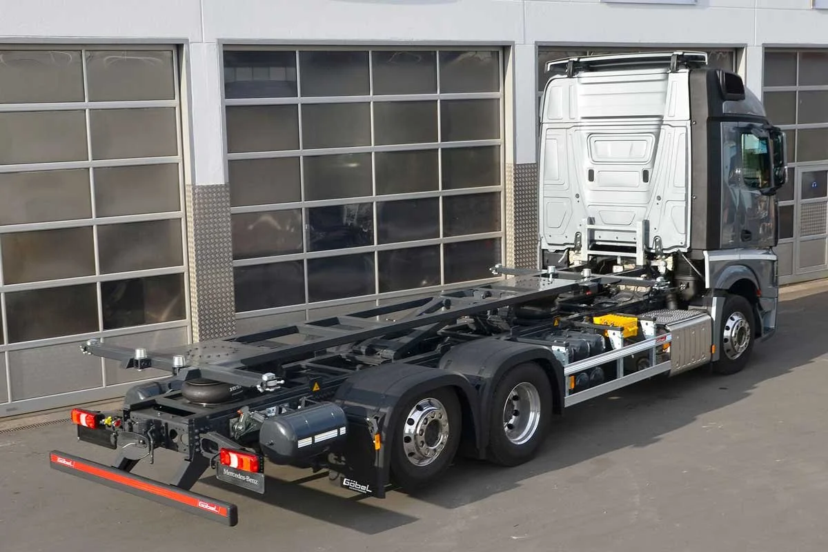 Ein leeres Lkw-Chassis ohne Auflieger vor einer Garage