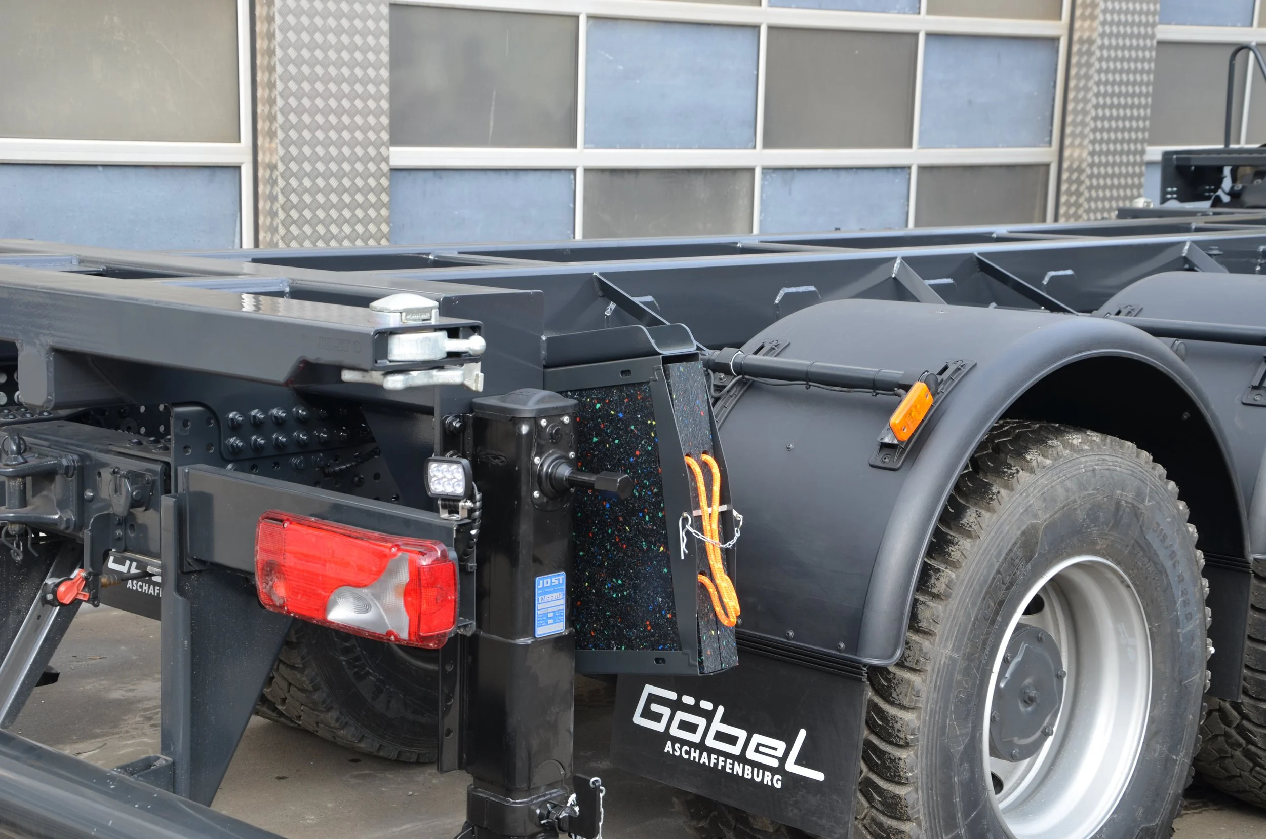 Gelber Iveco LKW aufgebaut von Göbel Fahrzeugbau als verwindungsarmer Transporter, seitliche Heckansicht von Auflage