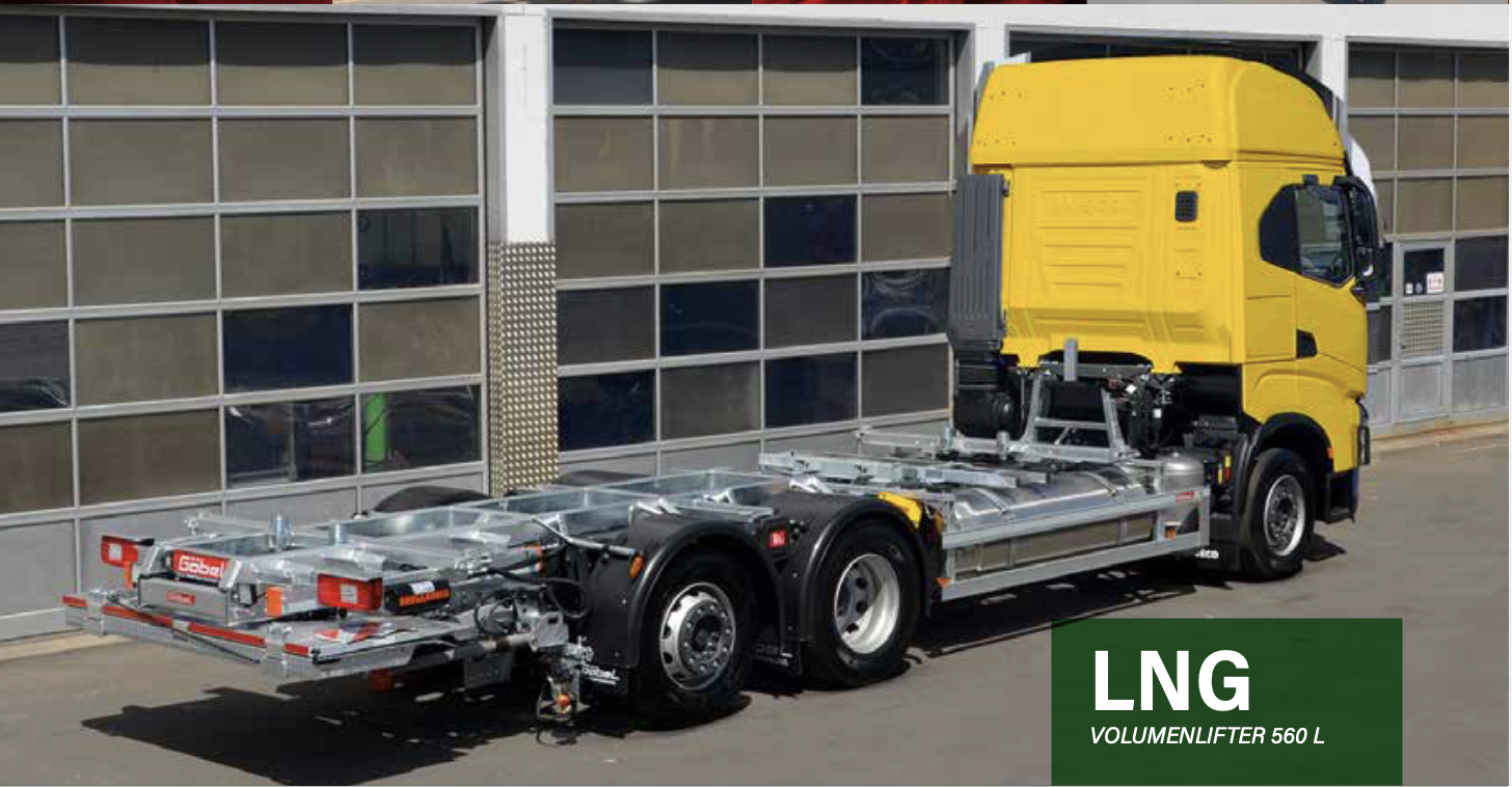 LKW auf einem Parkplatz vor einer modernen Gebäudefassade ohne Ladekasten, nur mit Chassis und Kabine, gelber Kabine, und ein grüner Textblock mit der Aufschrift 'LNG VOLUMENLIFTER 560 L'.