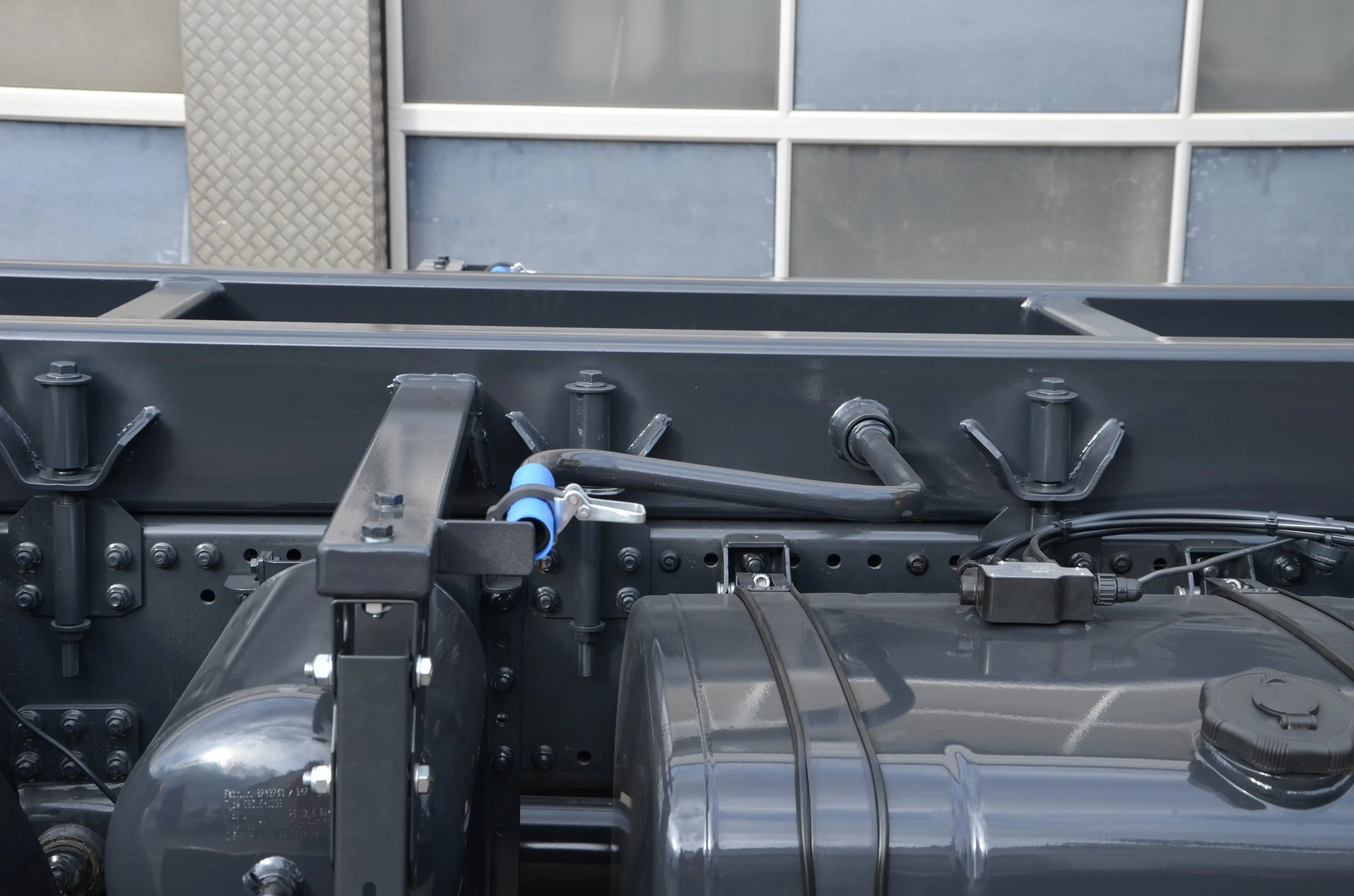 Nahaufnahme eines Metallrahmens mit mechanischen Komponenten und Kabeln, vermutlich Teil einer Maschine oder eines technischen Geräts.