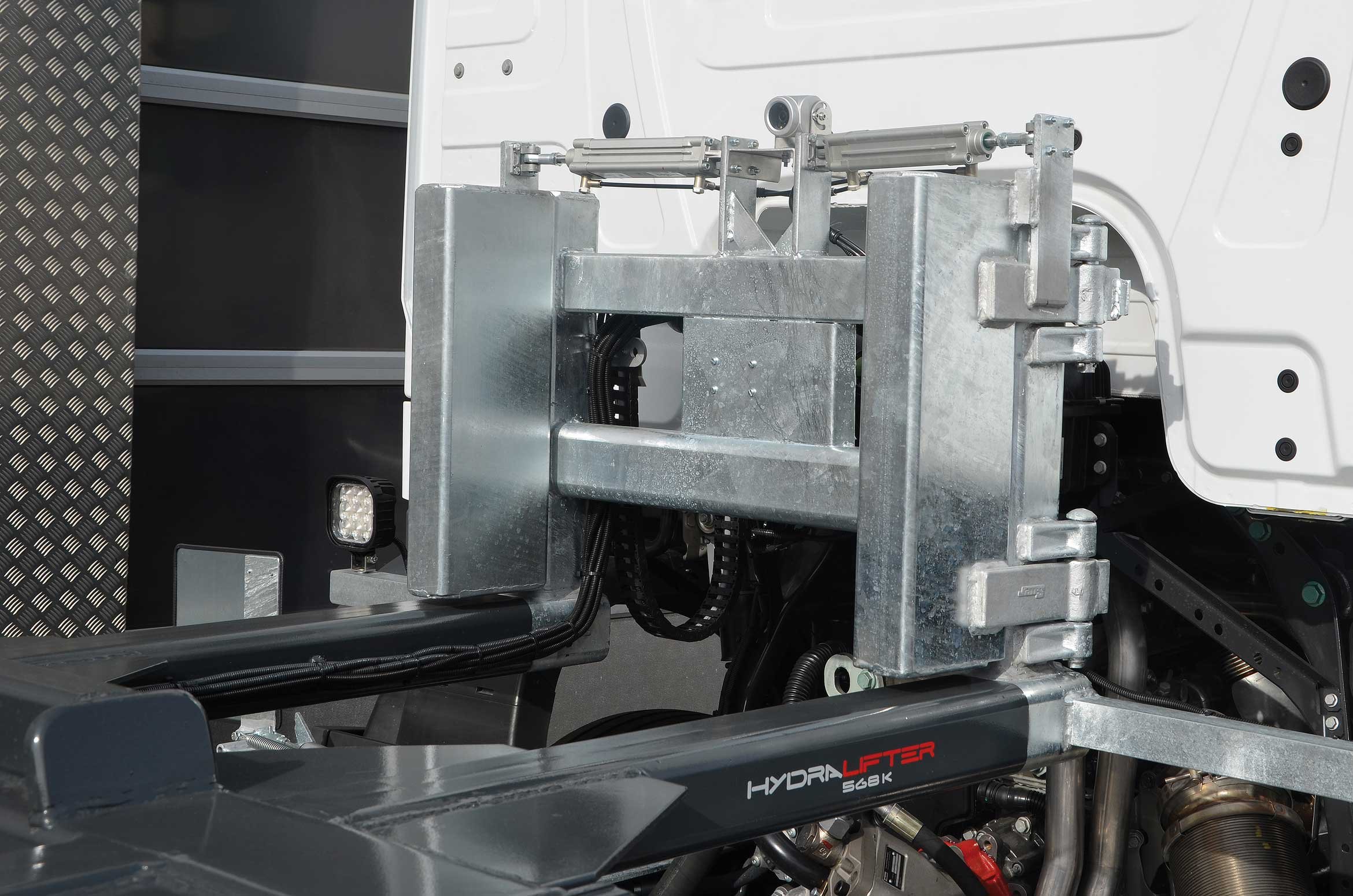 Nahaufnahme eines Airlifters und dessen mechanischen Hydraulikzylinders auf einer weißen Mercedes Benz Actros.