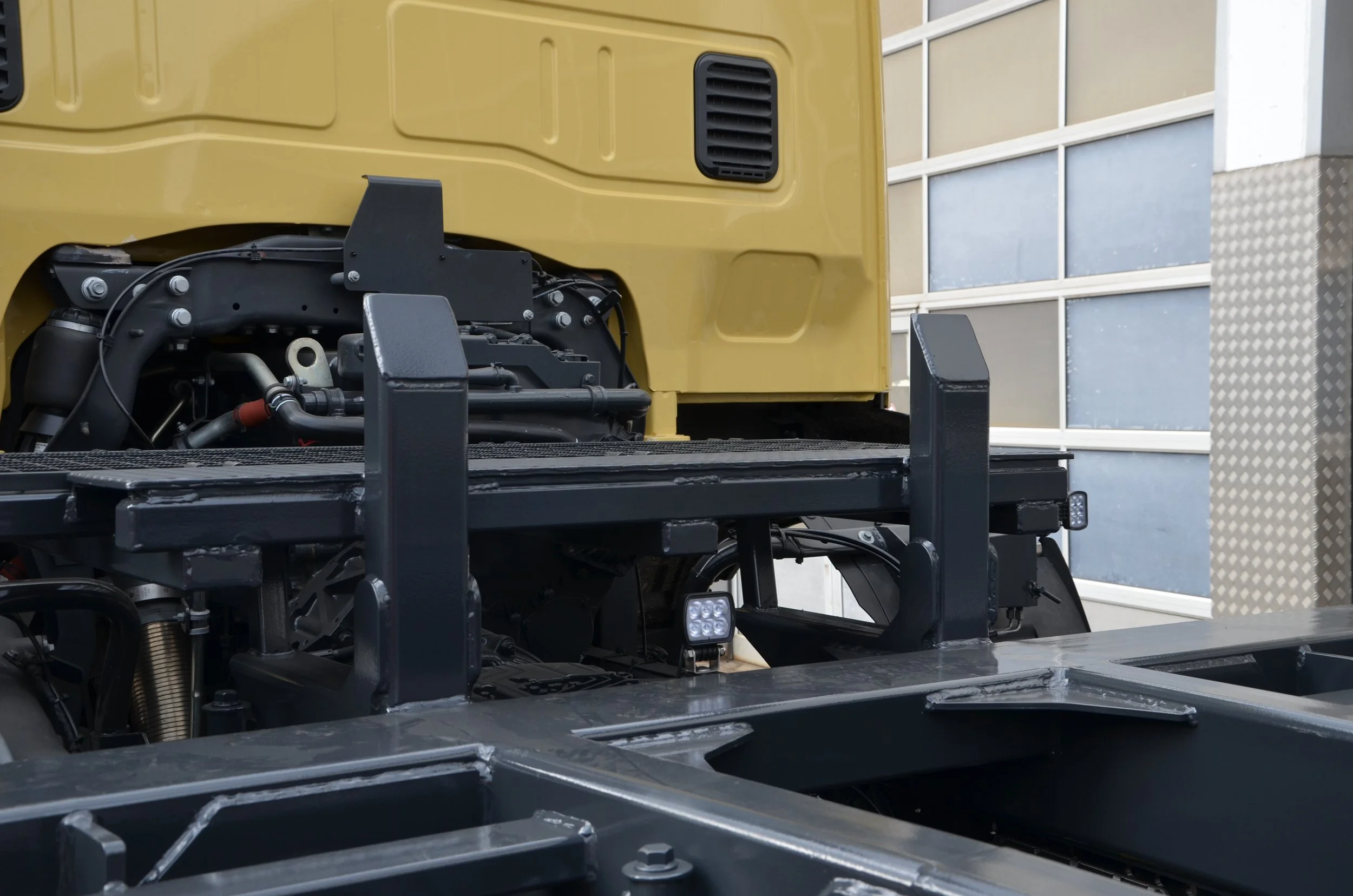 Gelber Iveco LKW aufgebaut von Göbel Fahrzeugbau als verwindungsarmer Transporter, Rückseite Fahrerkabine Auflage