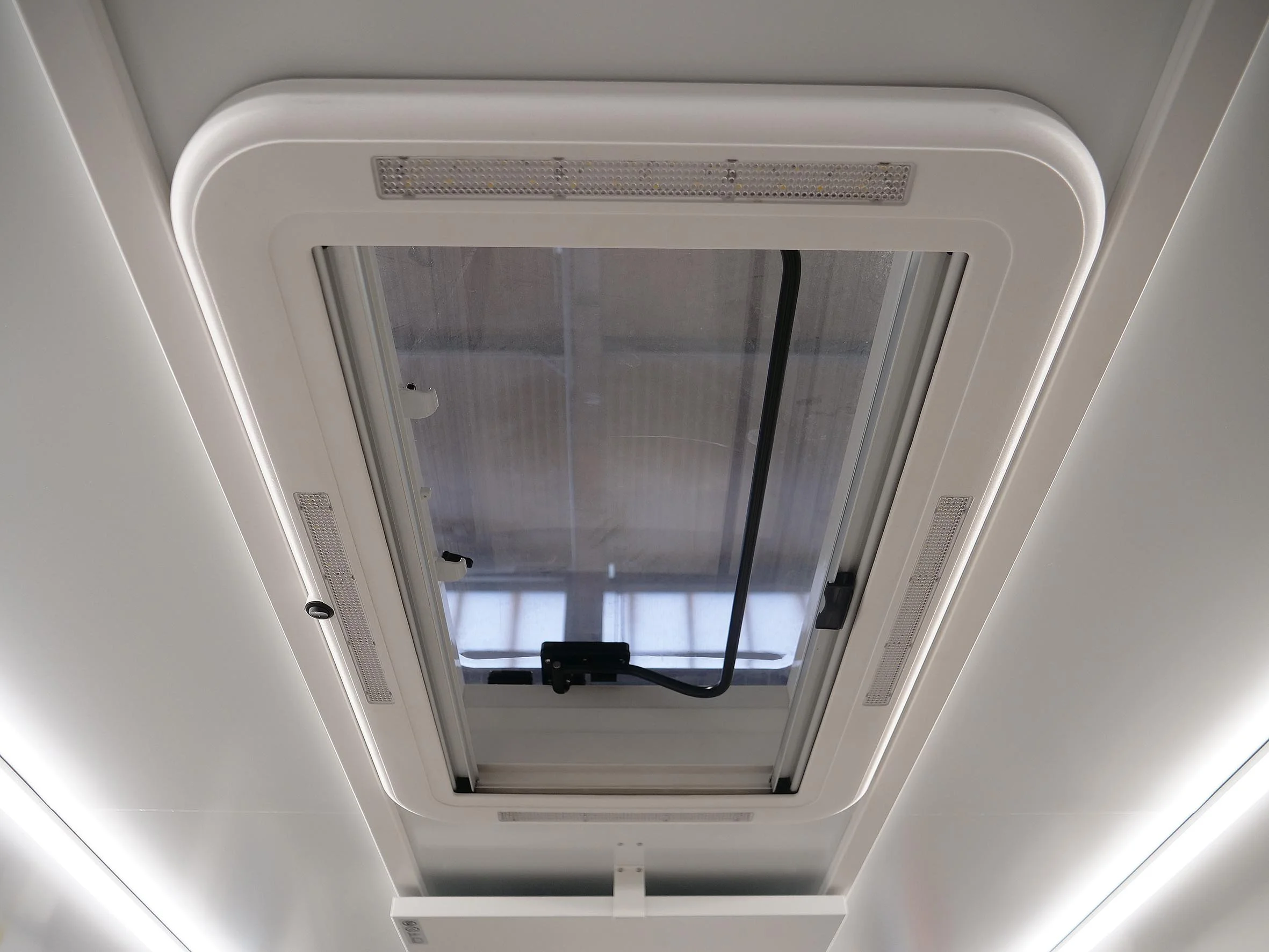 Dachfenster in einem weißen Raum, umrahmt von Lüftungsgittern. Kulturgutschutz Container Aufbau von Göbel Fahrzeugbau für Freistaat Bayern