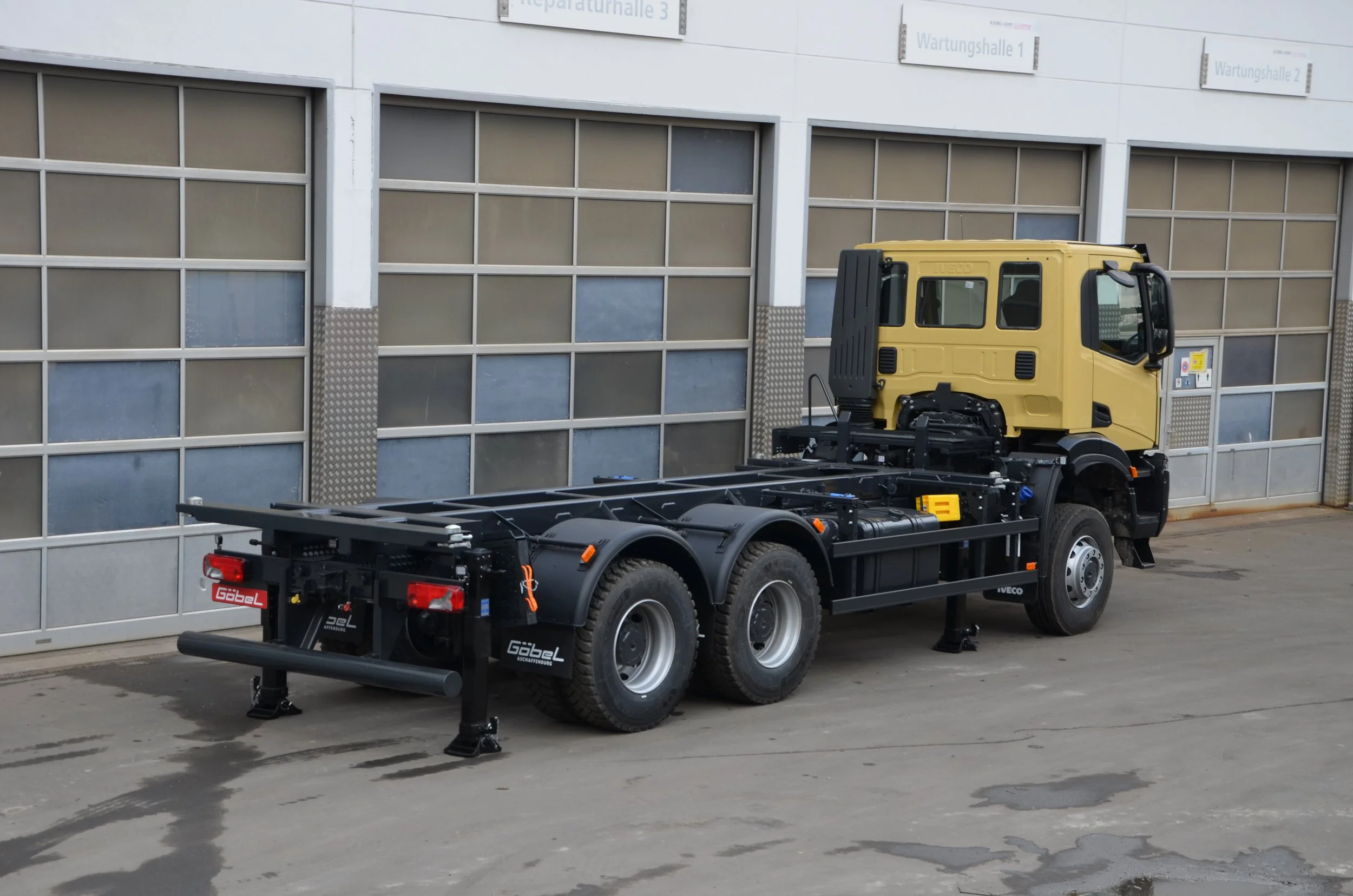 Ein gelber, verwendungsarmer Iveco LKW aufgebaut durch Göbel Fahrzeugbau. Ansicht von hinten.