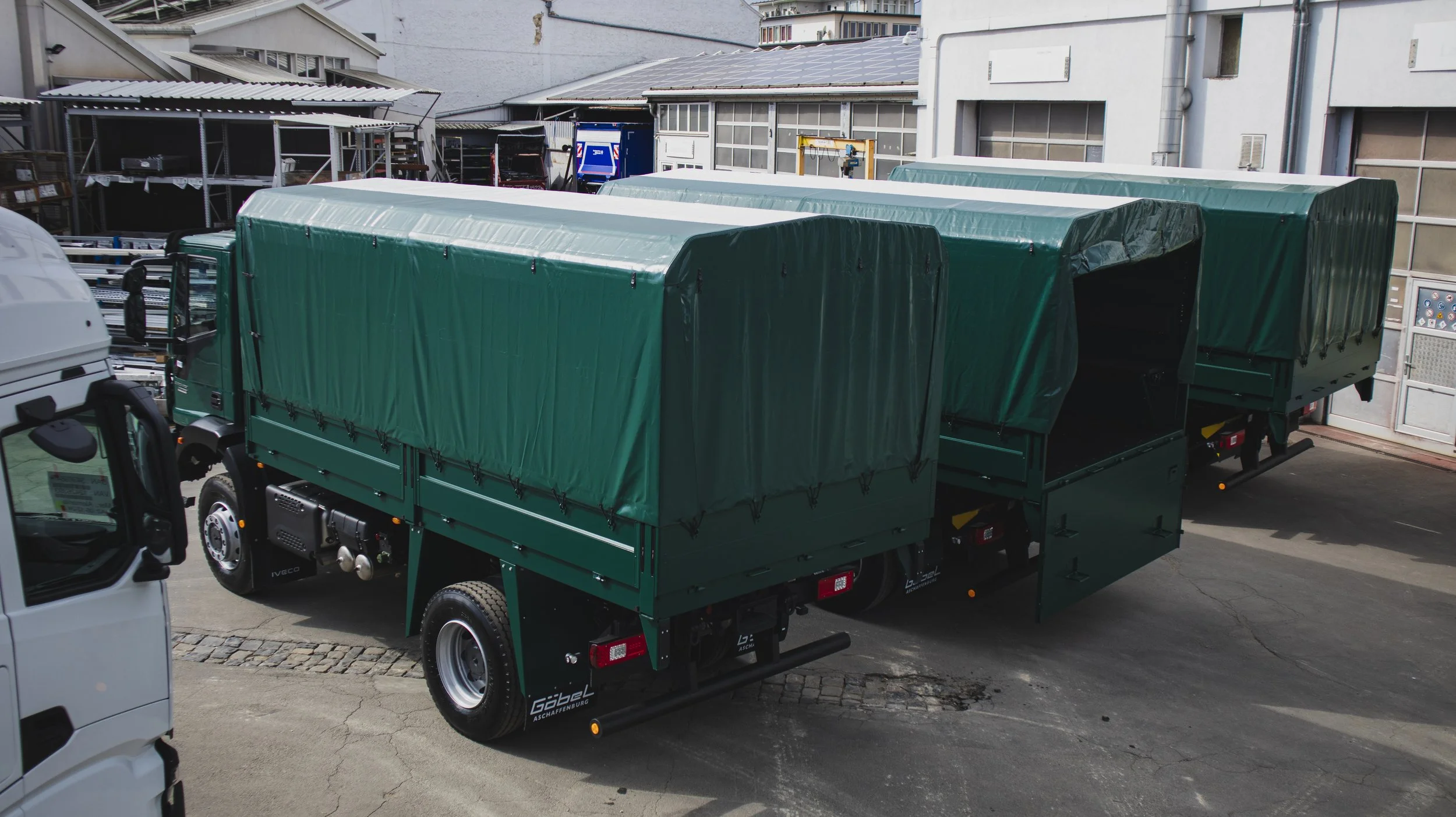 Drei grüne Iveco LKW aufgebaut als Truppentransporter von Göbel Fahrzeugbau. Ansicht von hinten.