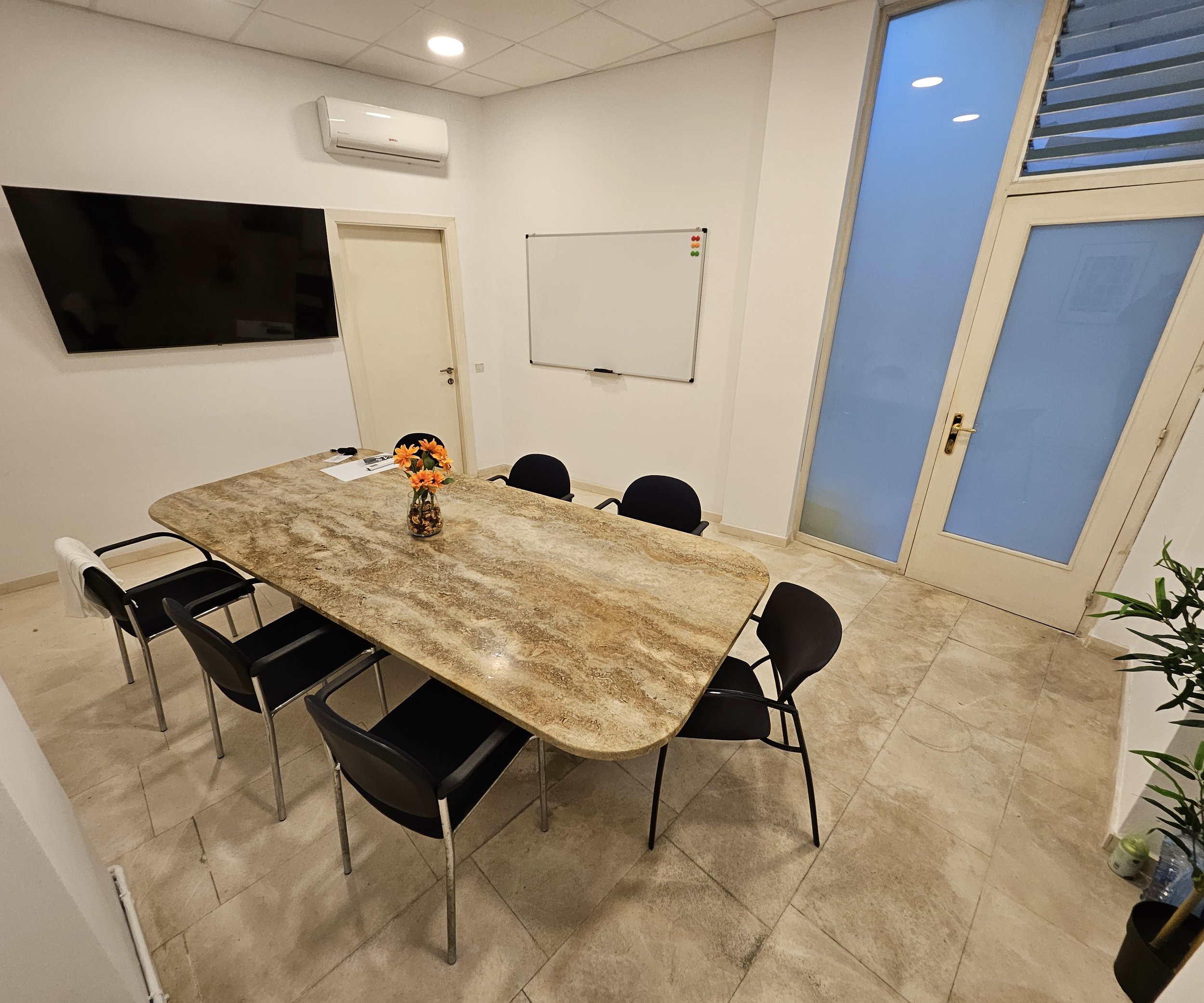 Sala de reuniones del coworking Nexum en Sant Celoni, con mesa para 10 personas, pantalla y pizarra