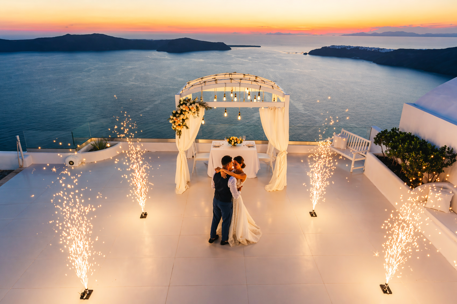 Luxury destination wedding ceremony at sunset in Santorini with couple under floral arch and fireworks overlooking the Aegean Sea