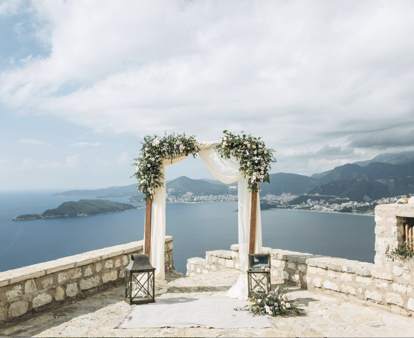Destination wedding ceremony setup in Europe with floral arch and scenic views