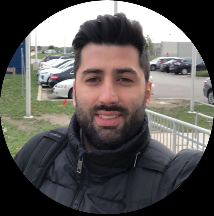 Man taking a selfie outdoors in a parking lot.