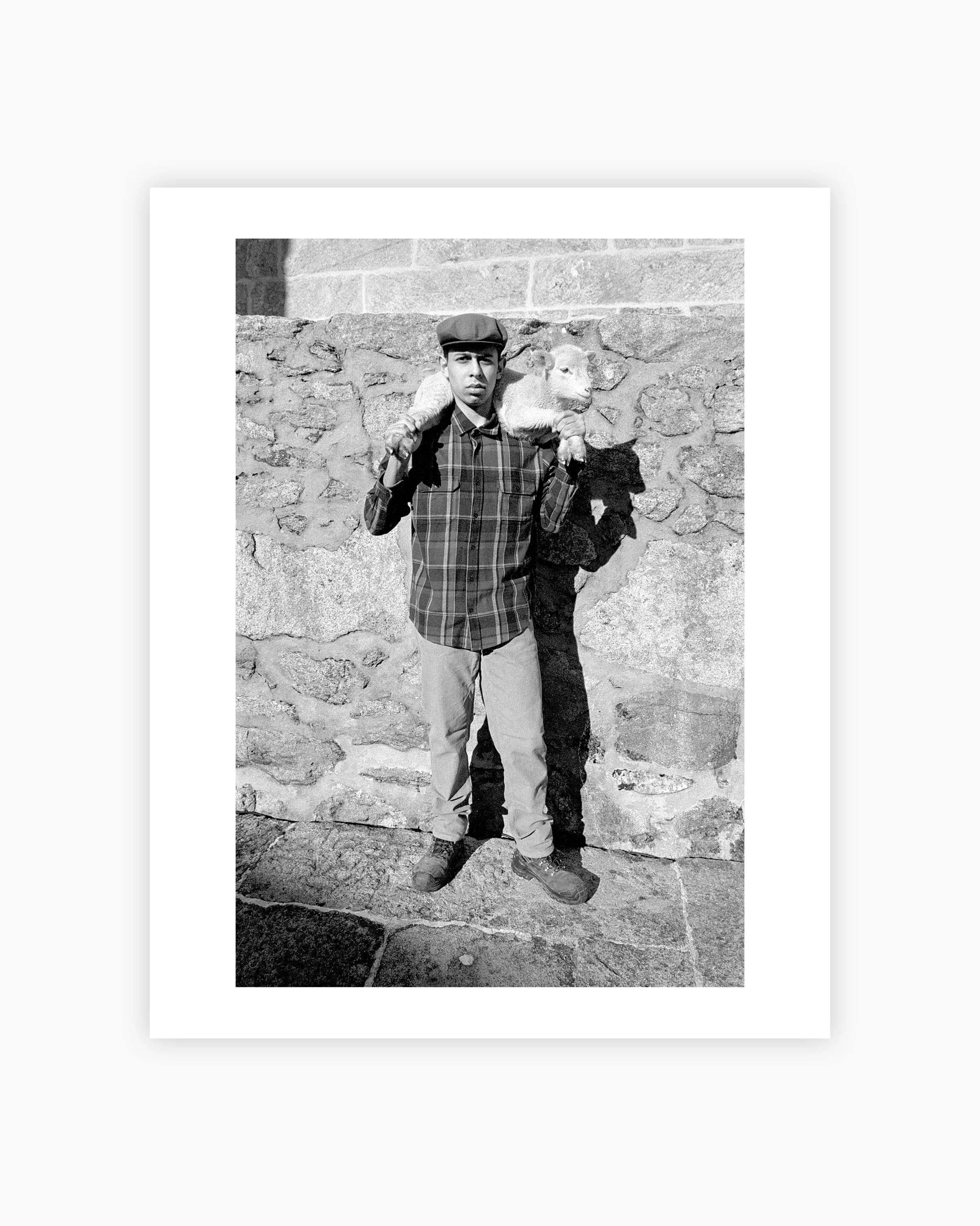 A young boy carrying a lamb on his shoulders. Viana do Castelo, Portugal. 2025.