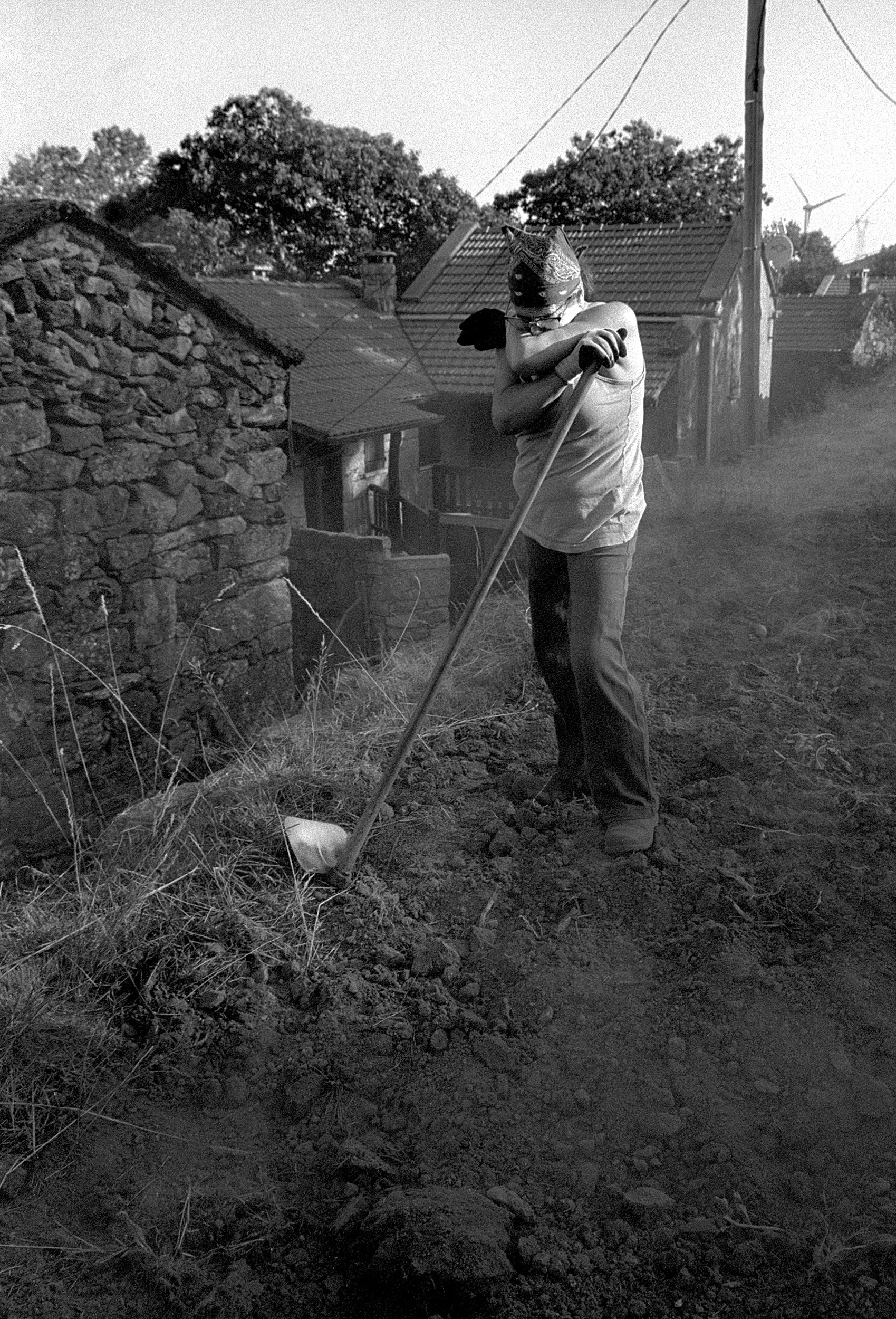 A woman with a hoe after working the land. Mourim, Portugal. 2025.