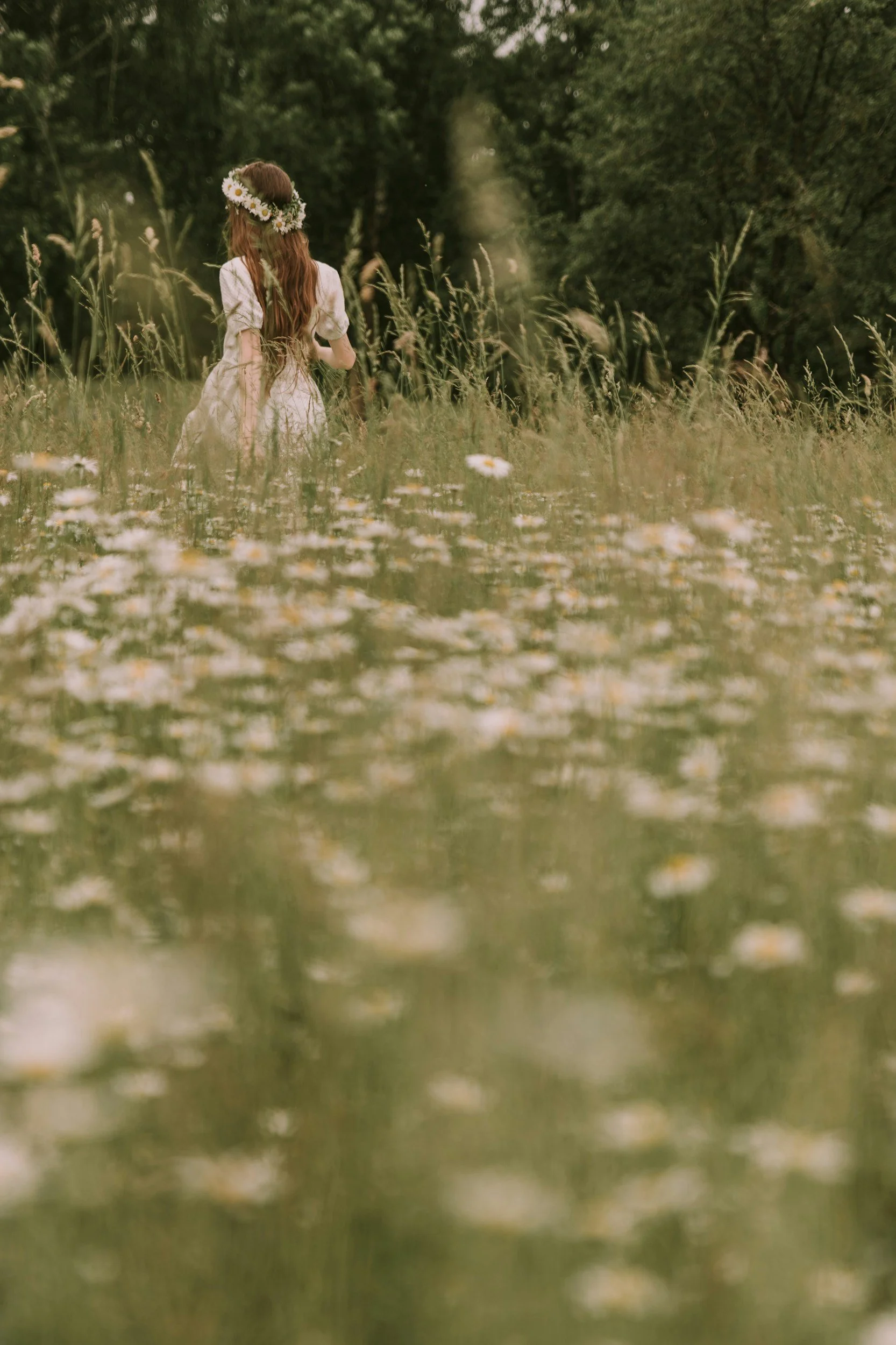 Woman standing in a field of flowers, symbolising strength and healing