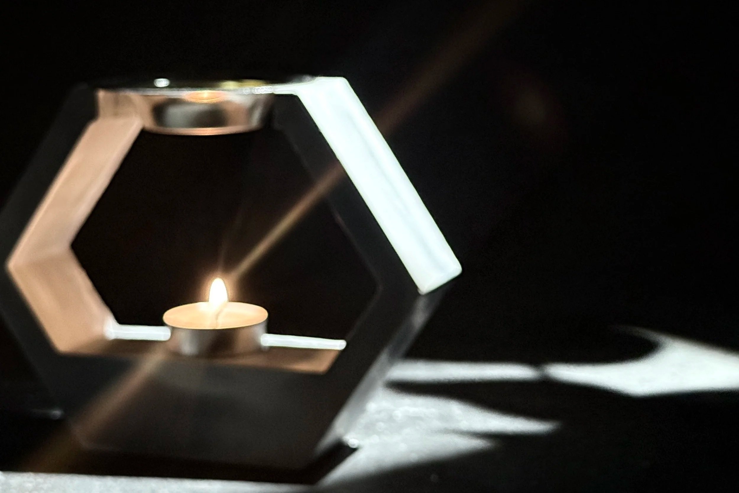 Close-up of a flame inside a black metal stove or oven with a small, bright orange and yellow flame at the bottom of the image.