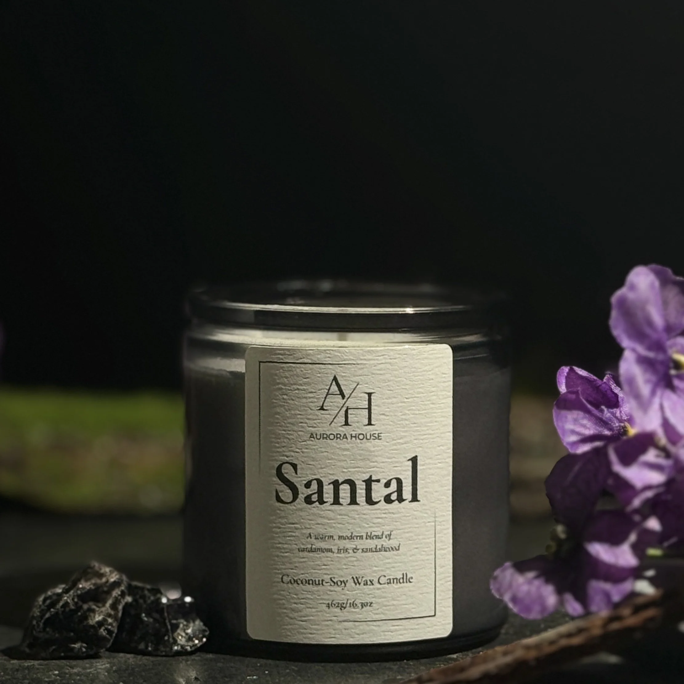 Aurora House 9oz candle Santal with earthy accents and violet stems