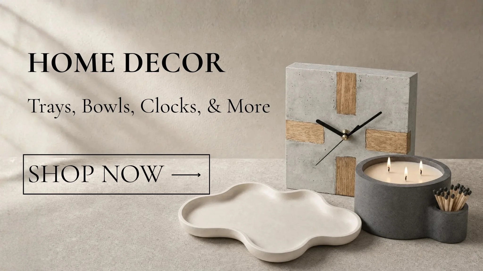 Handcrafted concrete home décor by Aurora House, featuring a wood-inlay clock, sculptural white tray, charcoal candle bowl, and matching holder styled in a warm, minimalist setting.