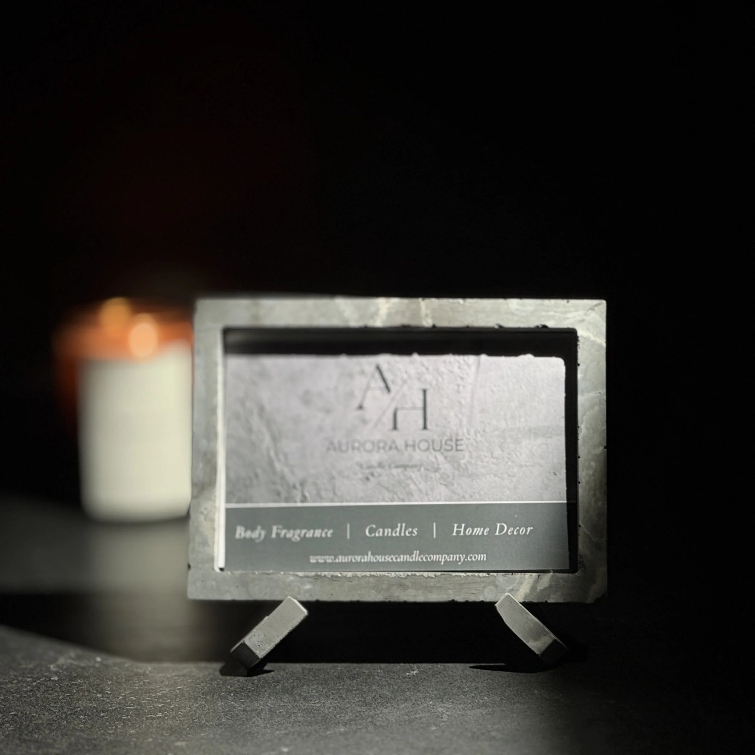 Aurora House Vista Frame in shadowed black background with out of focus candle in the background