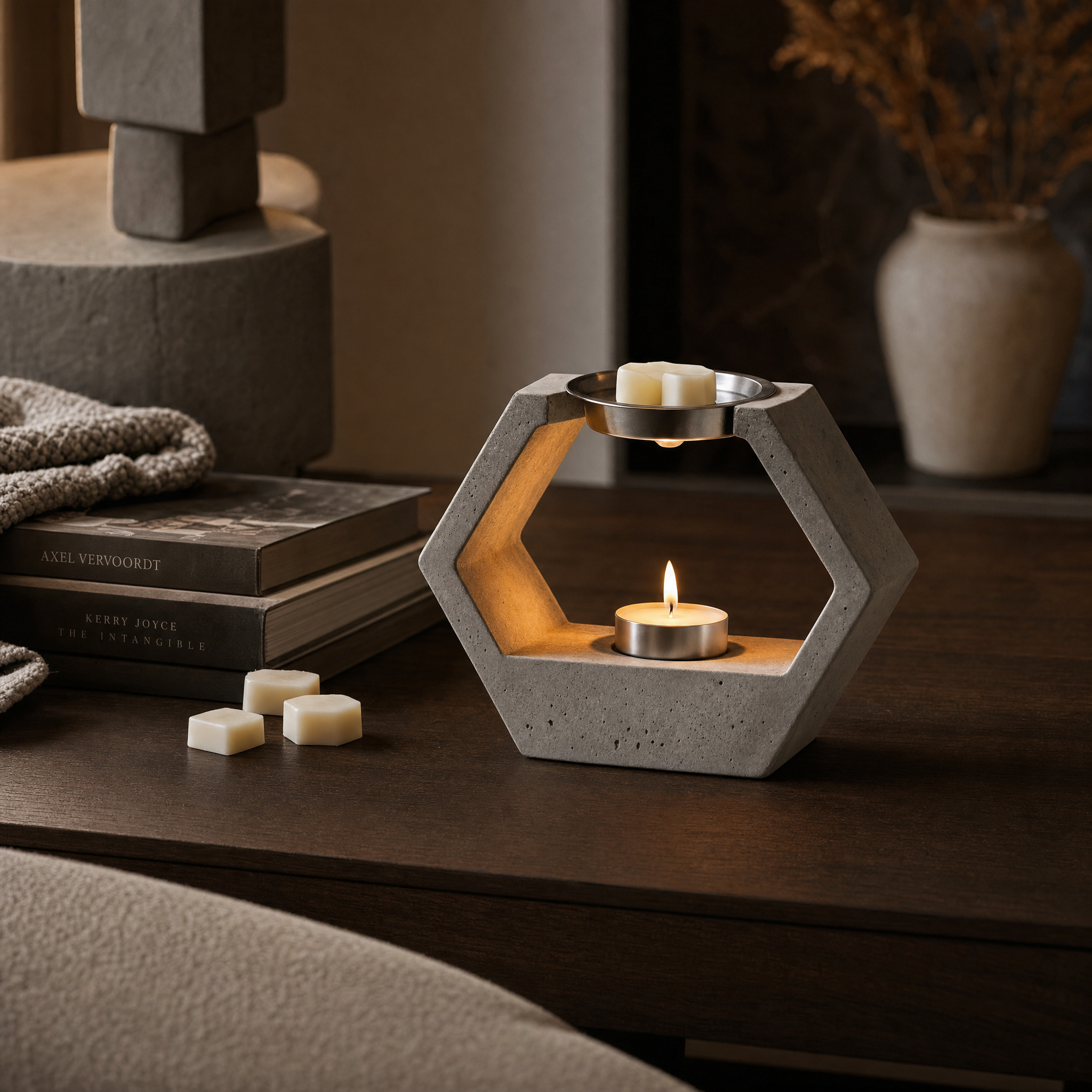 Geometric concrete wax melt burner glowing softly with a tea light and wax melts in a modern luxury interior.