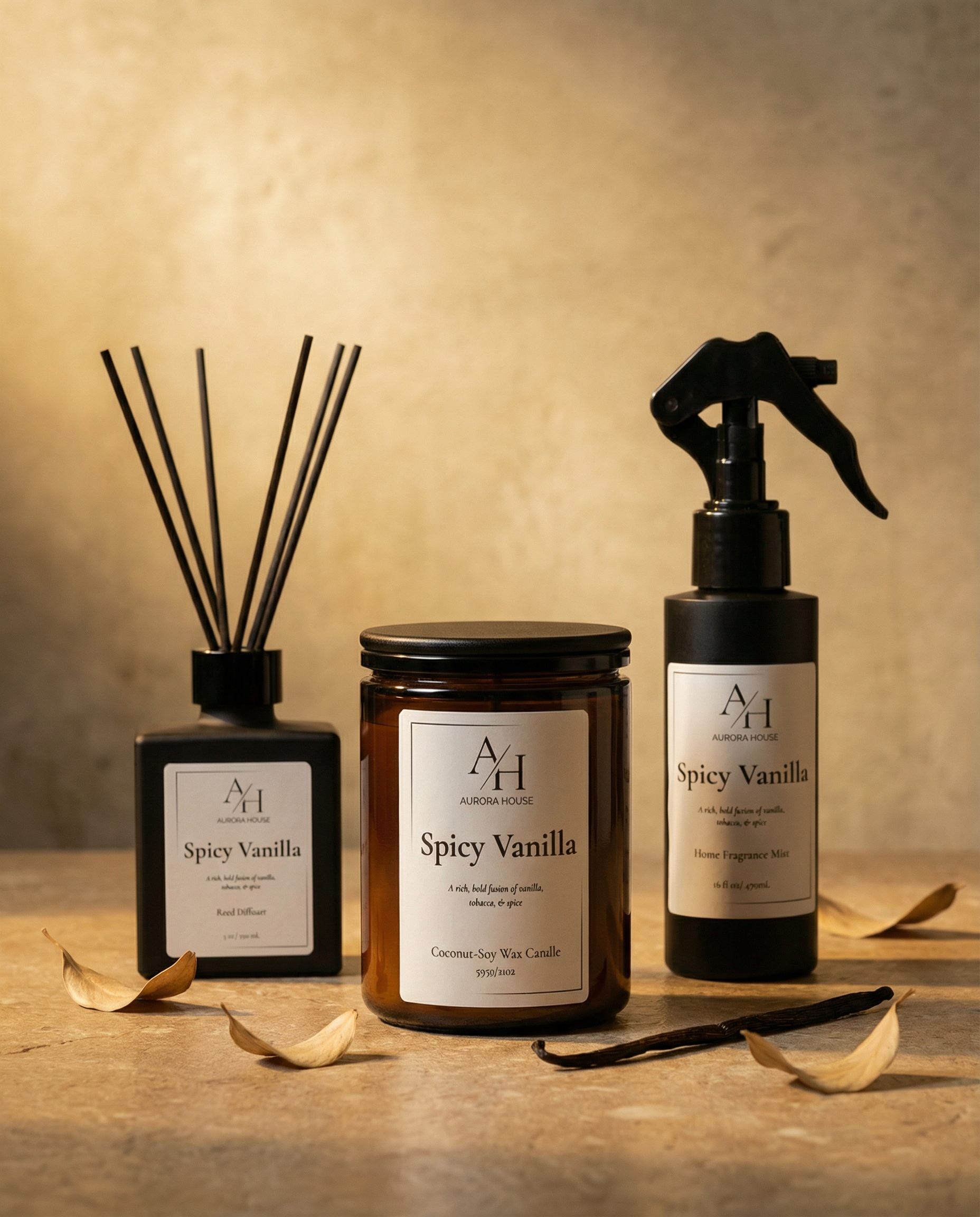 Spicy Vanilla candle, reed diffuser, and fragrance mist styled on neutral stone with vanilla pods and soft leaves.