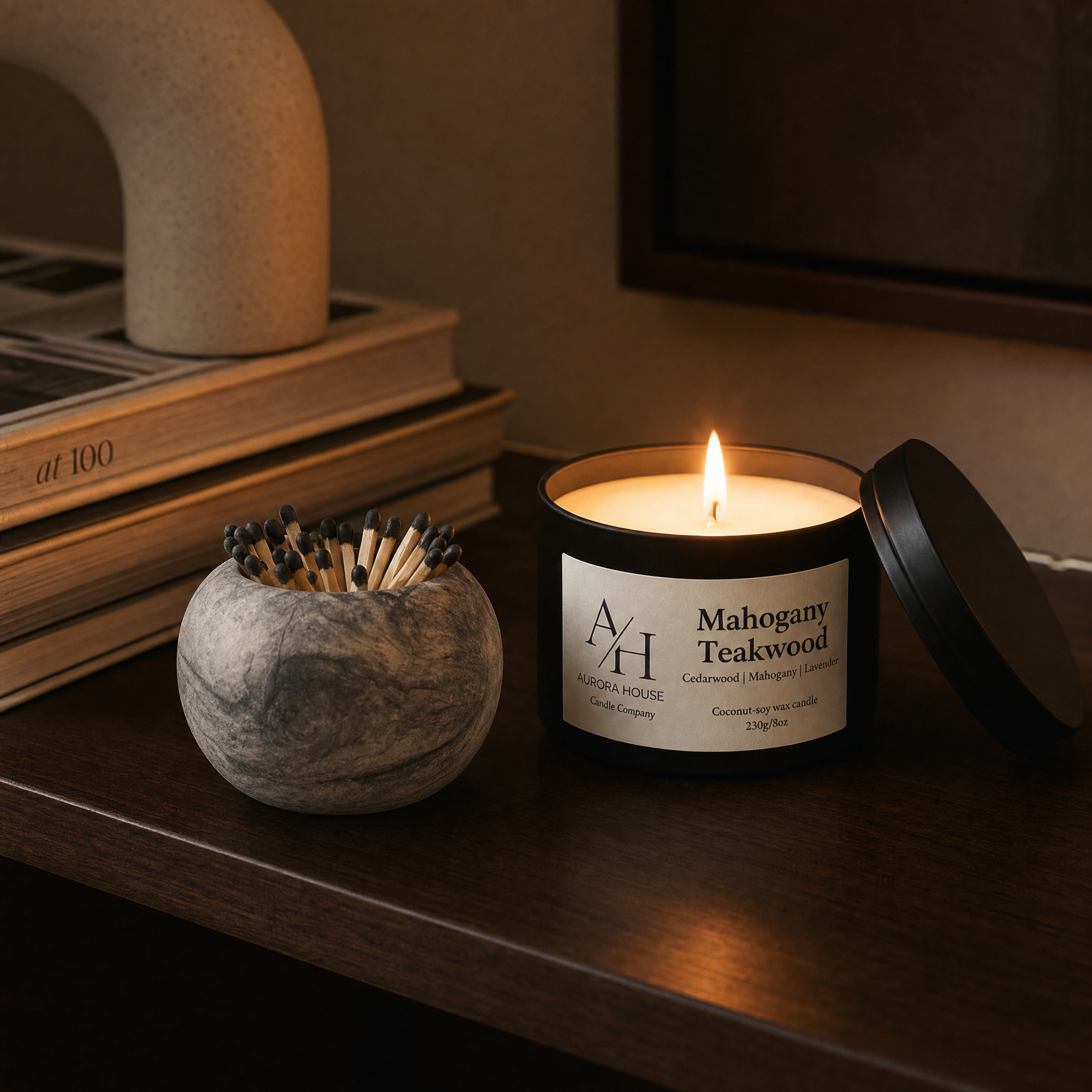 Concrete match holder displayed beside a candle with soft candlelight and architectural decor accents.