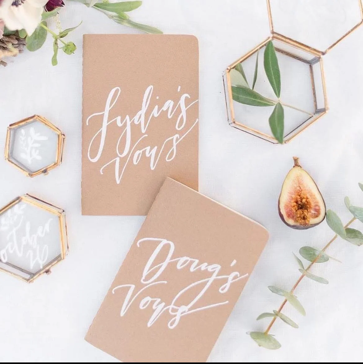 Tan Vow books with a few wedding details