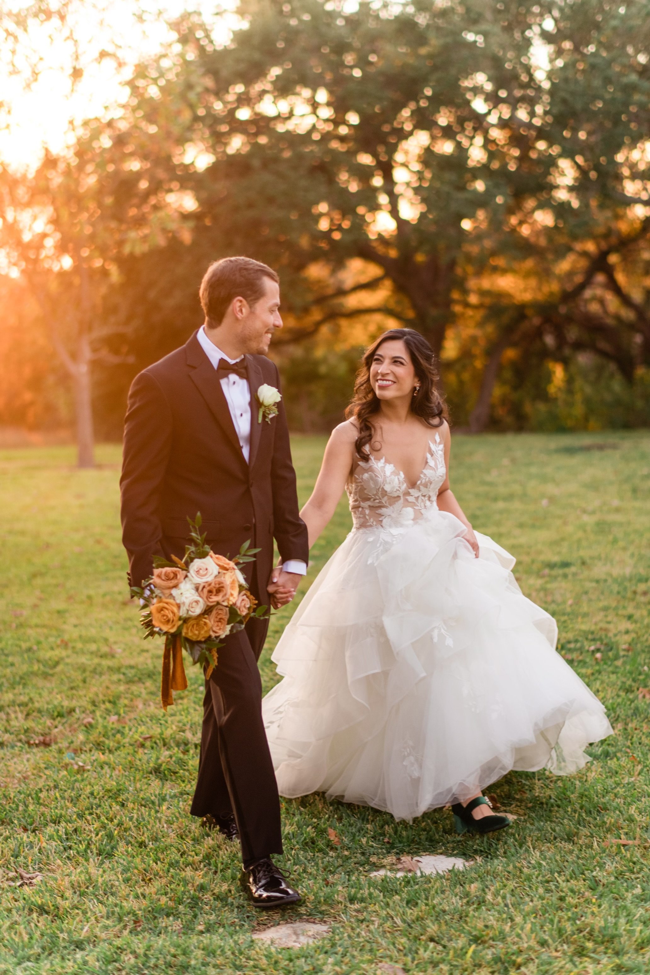 Newly married Couple walking hand and hand with the orange glow of sunset