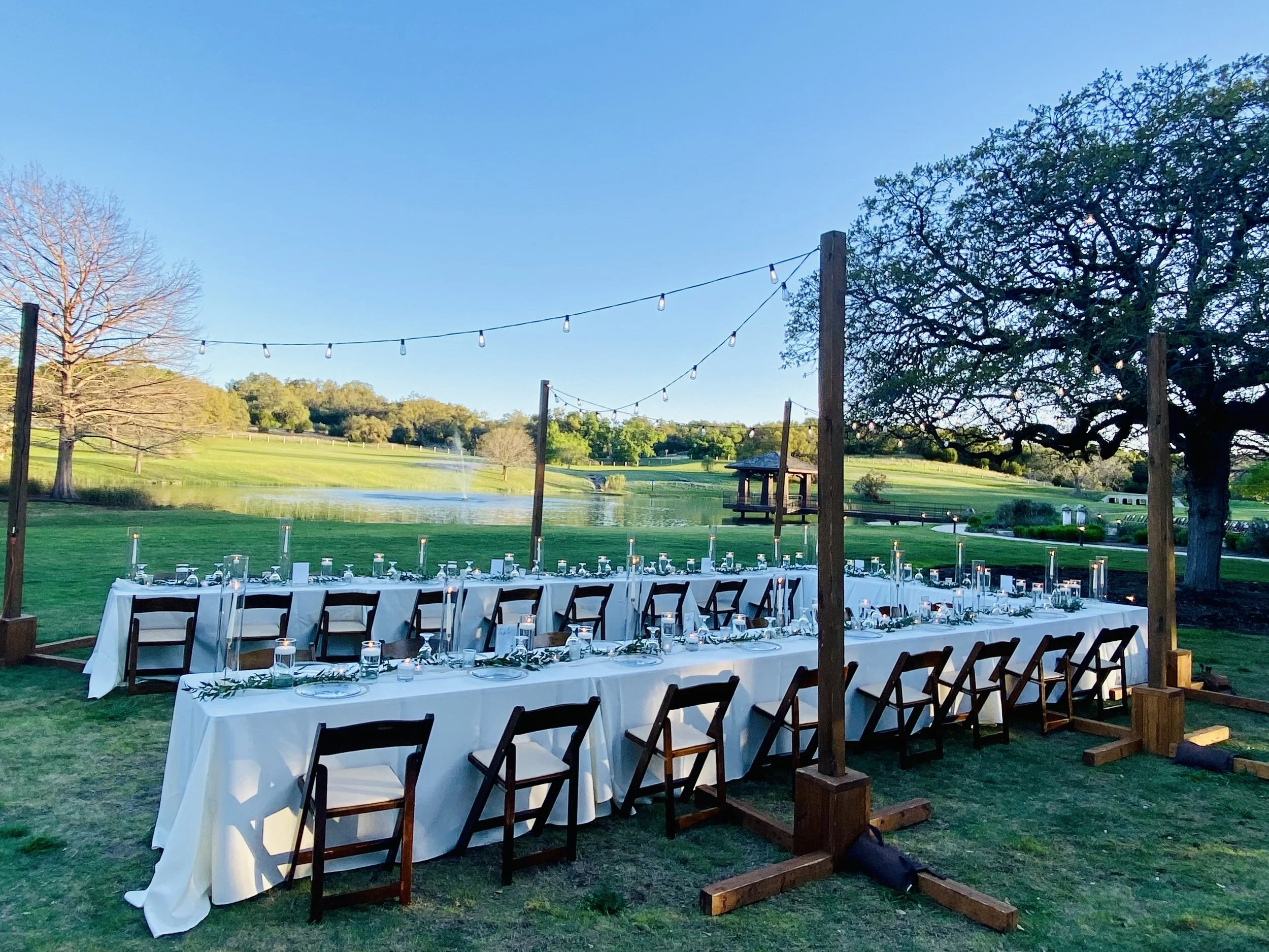 Long tables in a U-shape for a small wedding at Garey House in the lawn by the pond