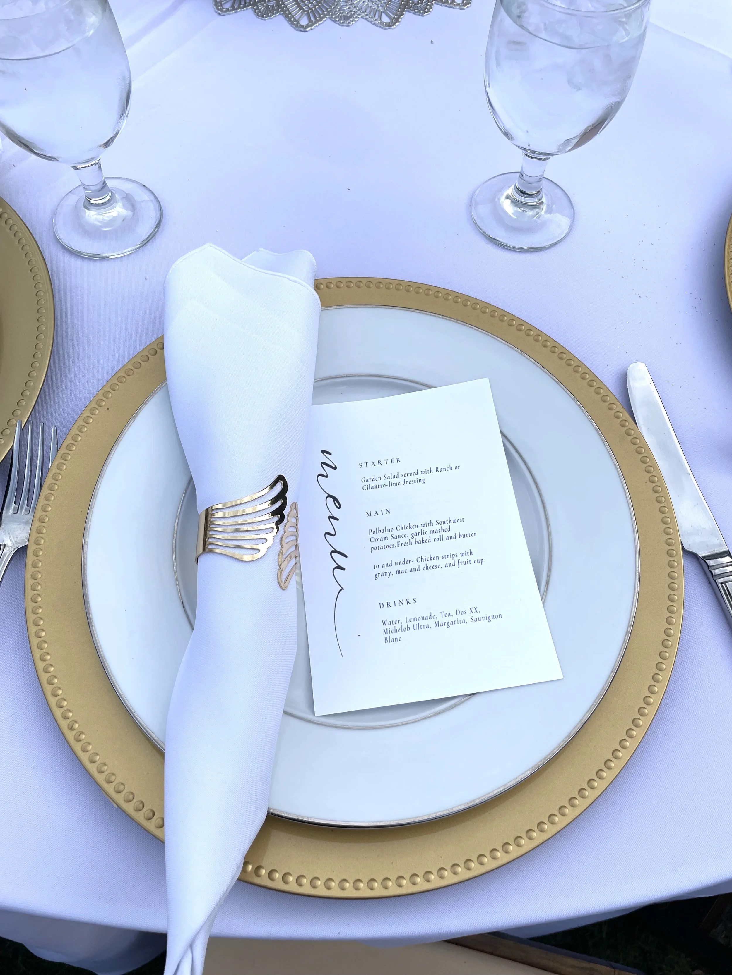 Gold Charger with a white place, Gold writing dinner menu, and Wrapped utensils with a gold wrap
