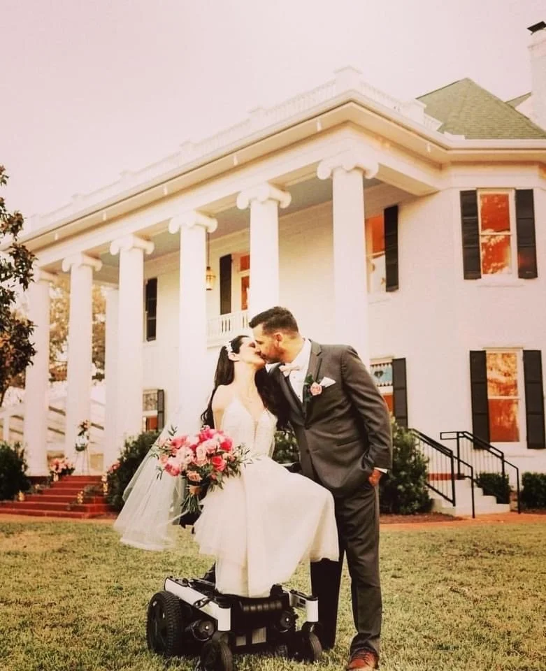 Disabled couple kissing in front of Woodbine Mansion in Round Rock Texas