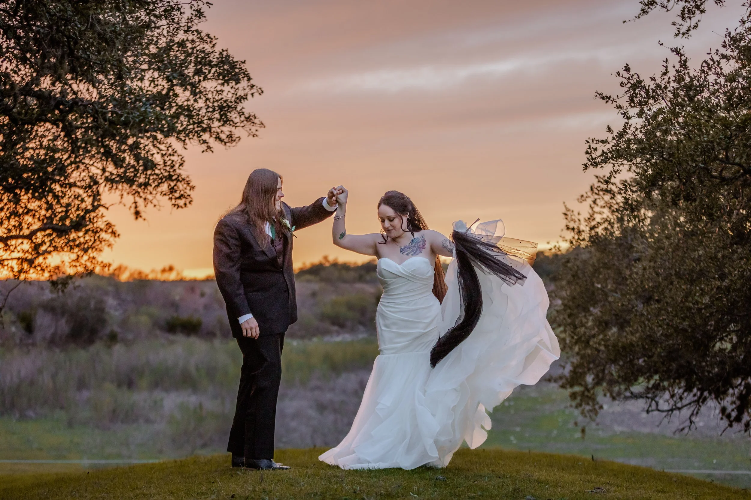 Couple spinning at dusk and bride wearing a black veil at Carriage Hills Venue in Blanco Texas and photo by Full Scope Entertainment
