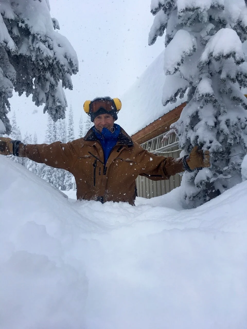 Lodge owner and operator hip deep in backcountry fresh powder snow around Sol