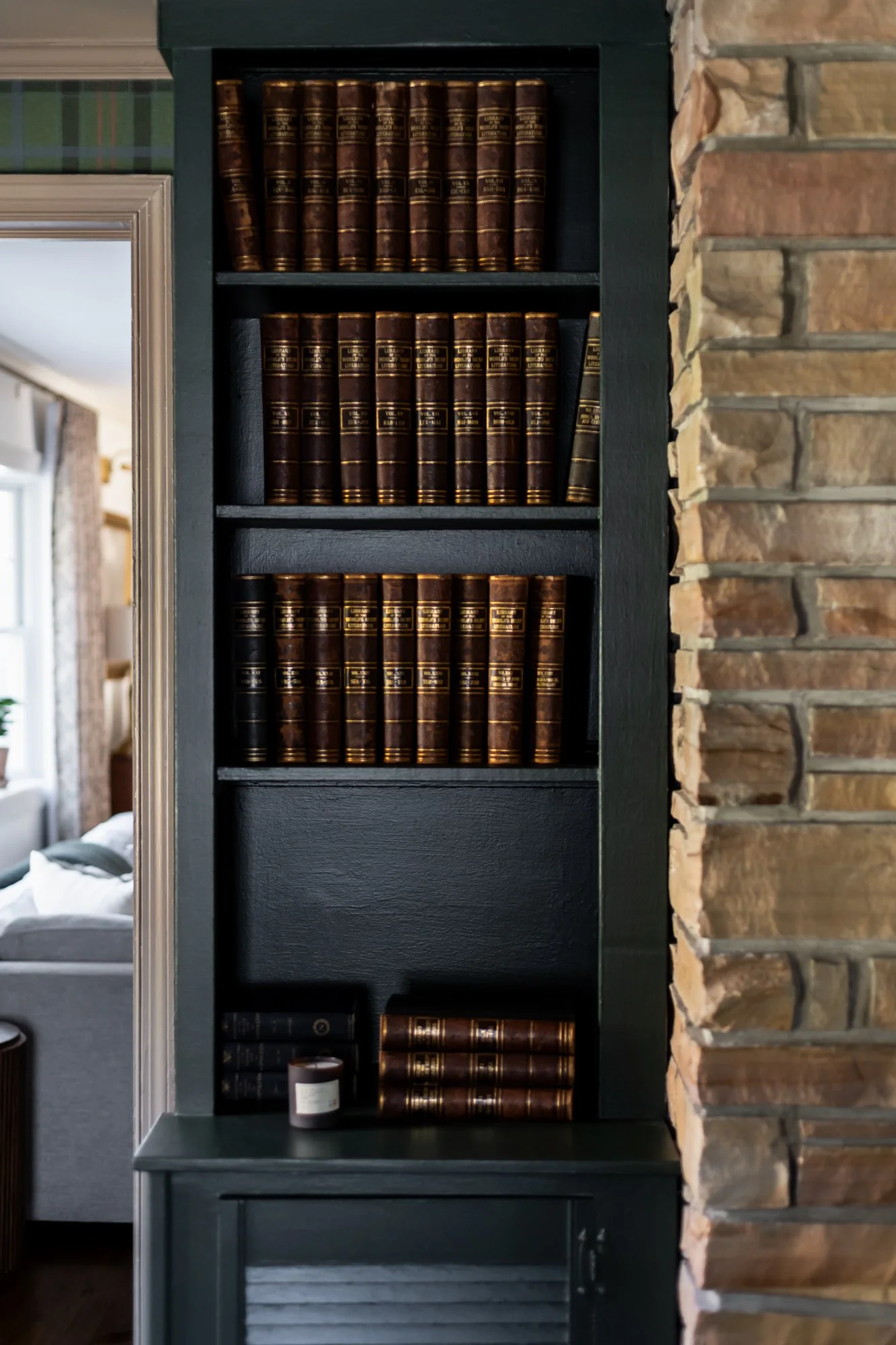Bookcase filled with leather-bound books in a cozy living room