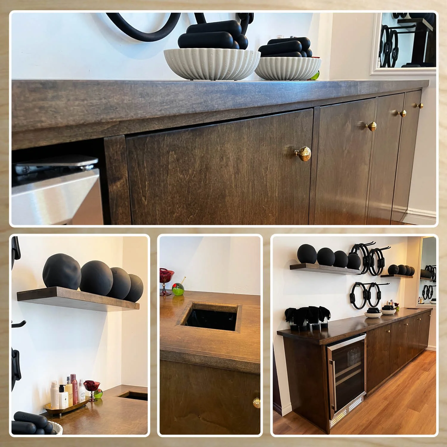 A modern wooden sideboard with gold knobs, decorated with black stone objects, bowls, and wall-mounted black circular decorations in a contemporary interior.