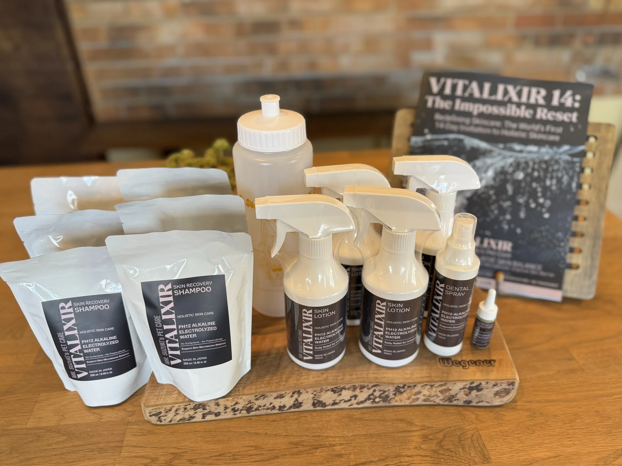 Mr. Suzuki’s VITALIXIR skin care products displayed together, including Skin Recovery Shampoo, Skin Lotion, Rescue Butter, Dental Spray, and a mixing bottle.