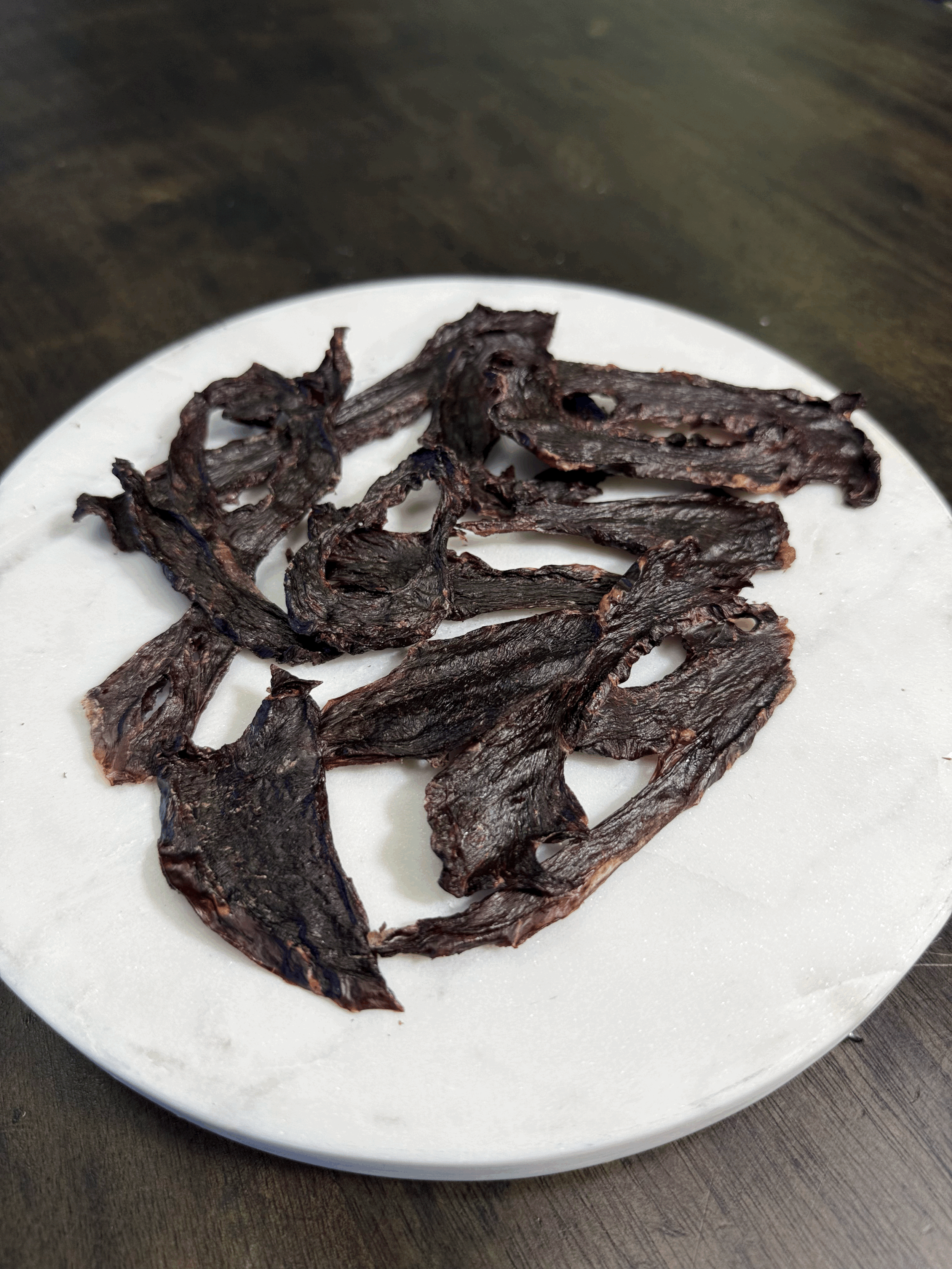 Close-up of sliced air-dried emu heart pieces on neutral background.