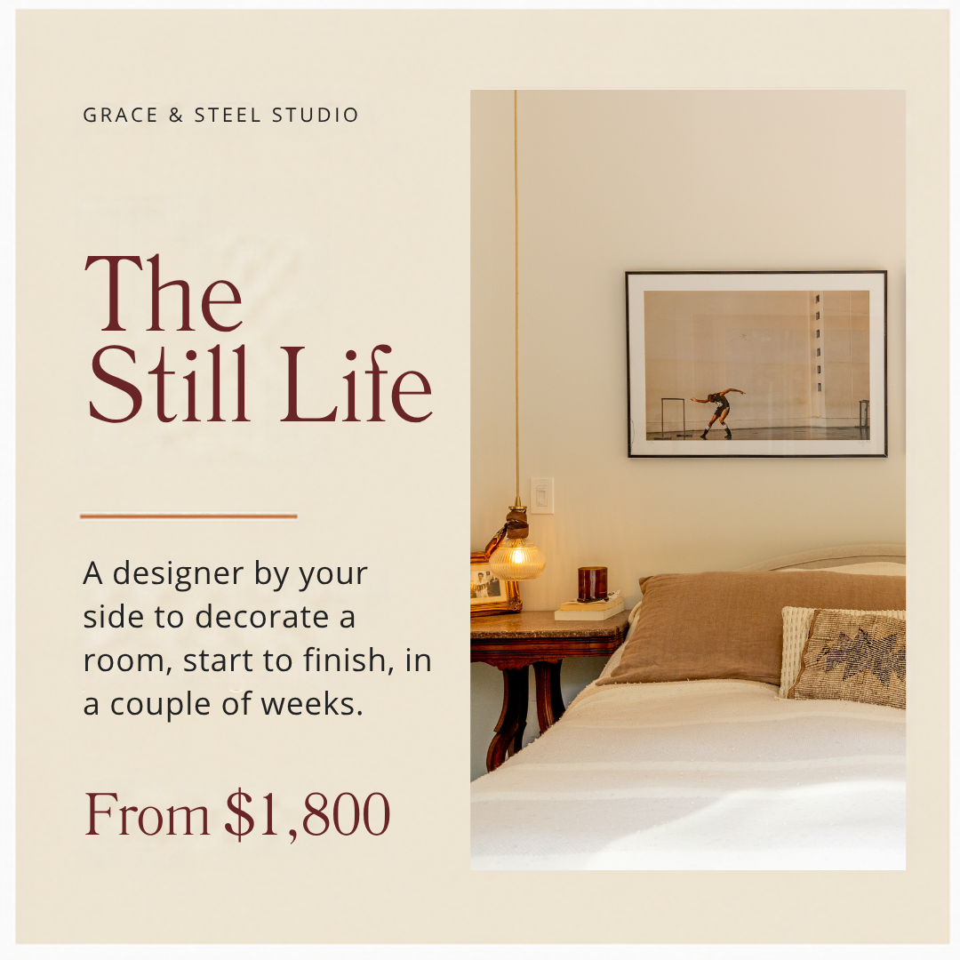 An interior bedroom scene with a bed, bedside table, and framed art of a figure skating skater on the wall.
