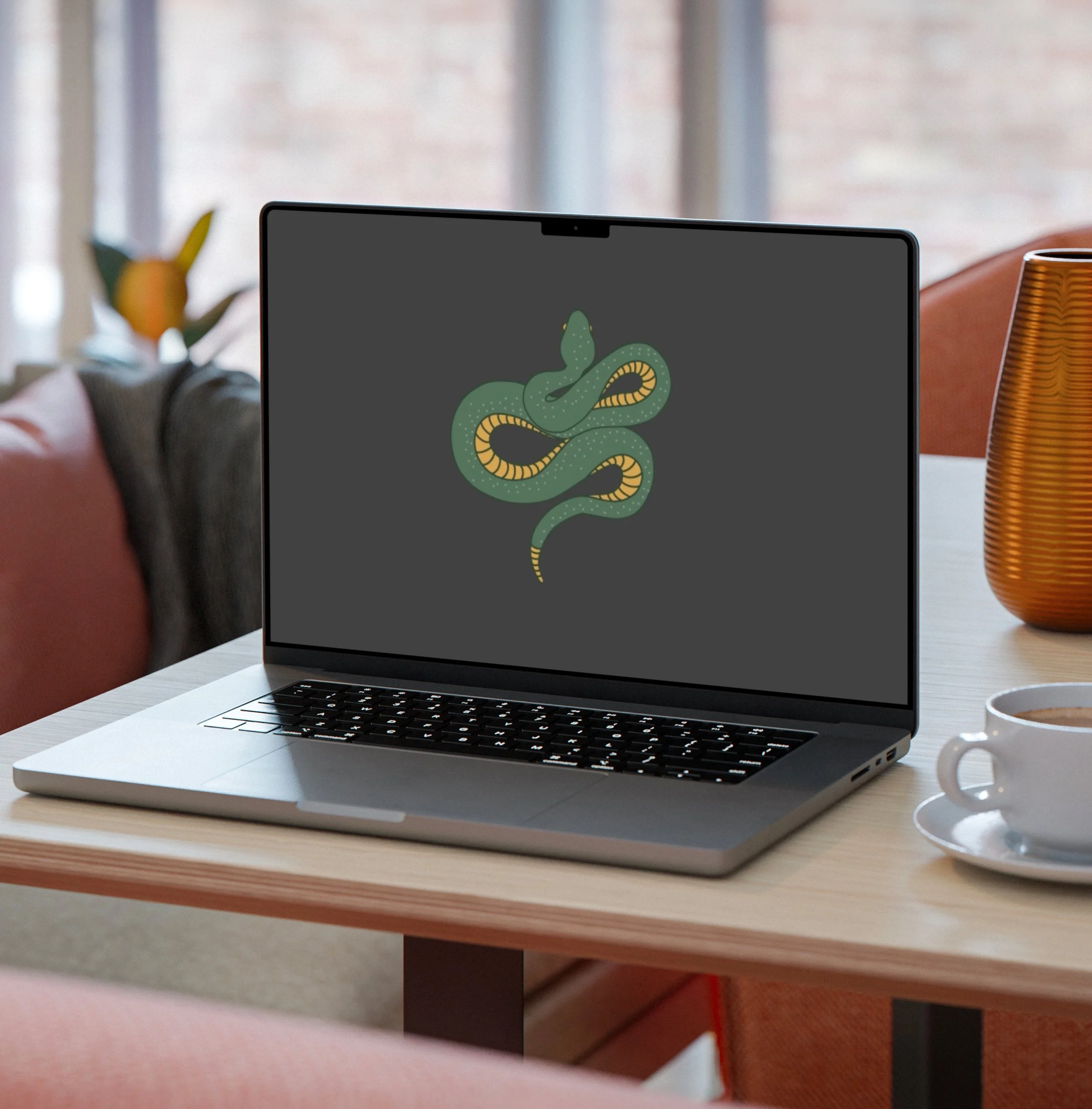 Laptop on a table with a snake illustration on the screen, next to a cup and a plant in the background.