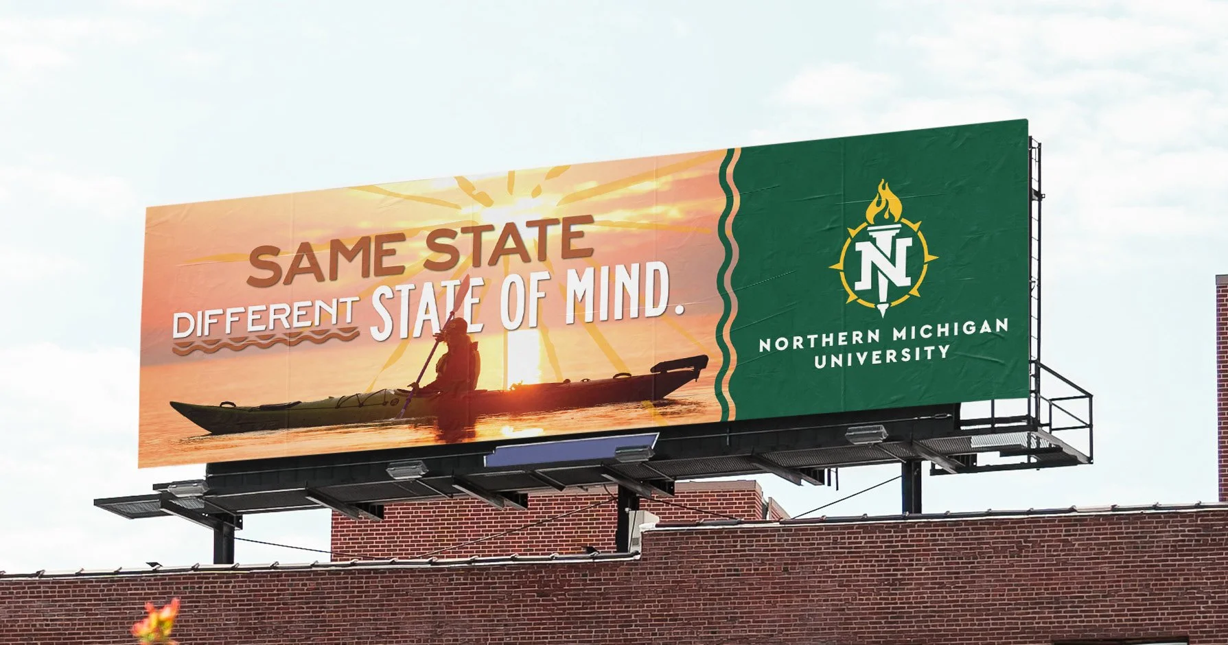 Billboard for Northern Michigan University with a person kayaking against a sunset background, featuring the text "Same State, Different State of Mind."