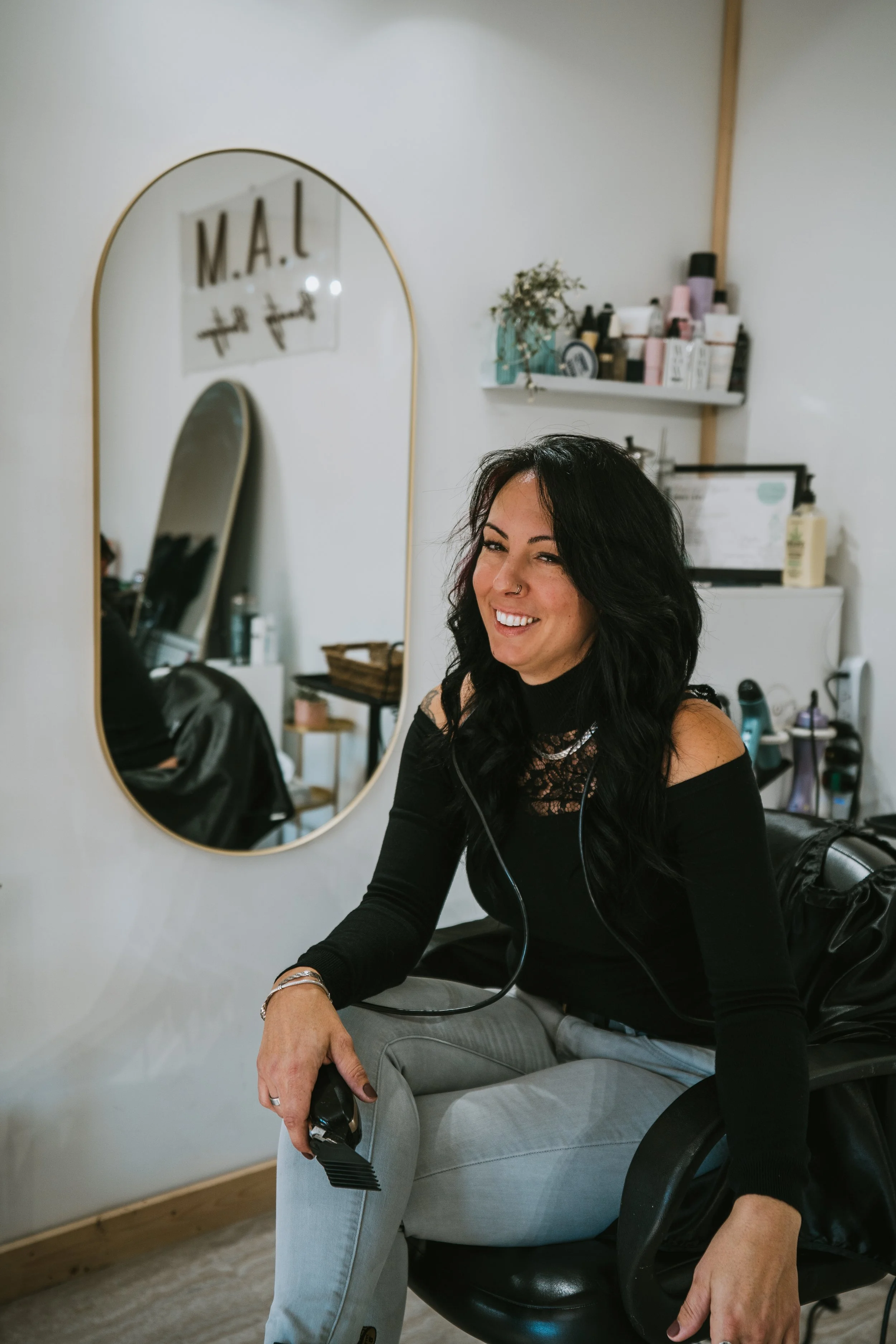 Branding photo of hairstylist in a salon with clippers in hand