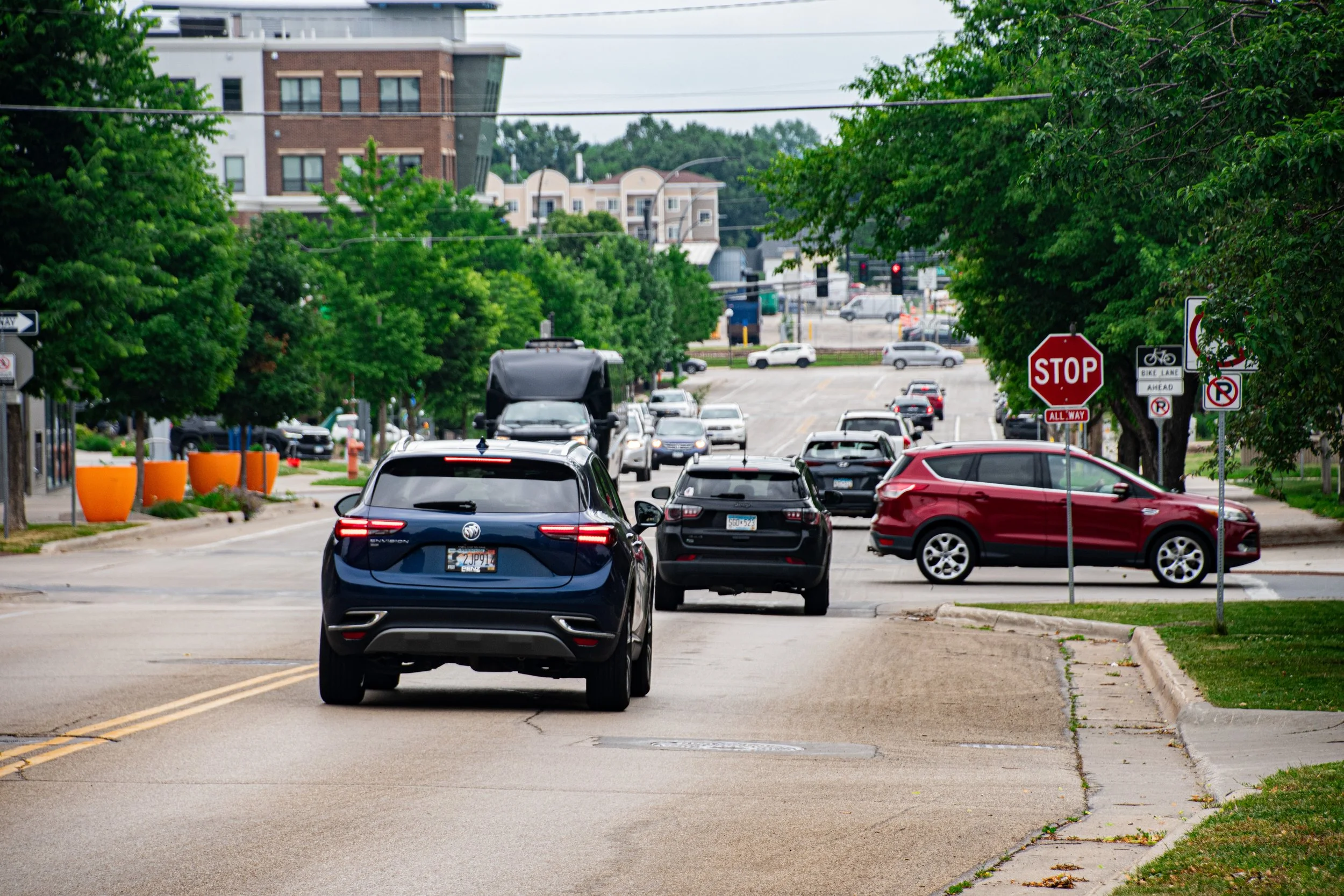 vehicles driving on a downtown street during daylight