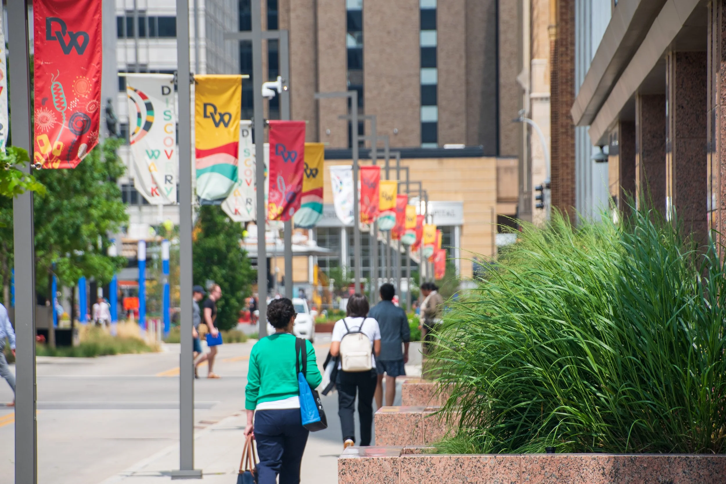 people walking a busy downtown street facing away from the camera