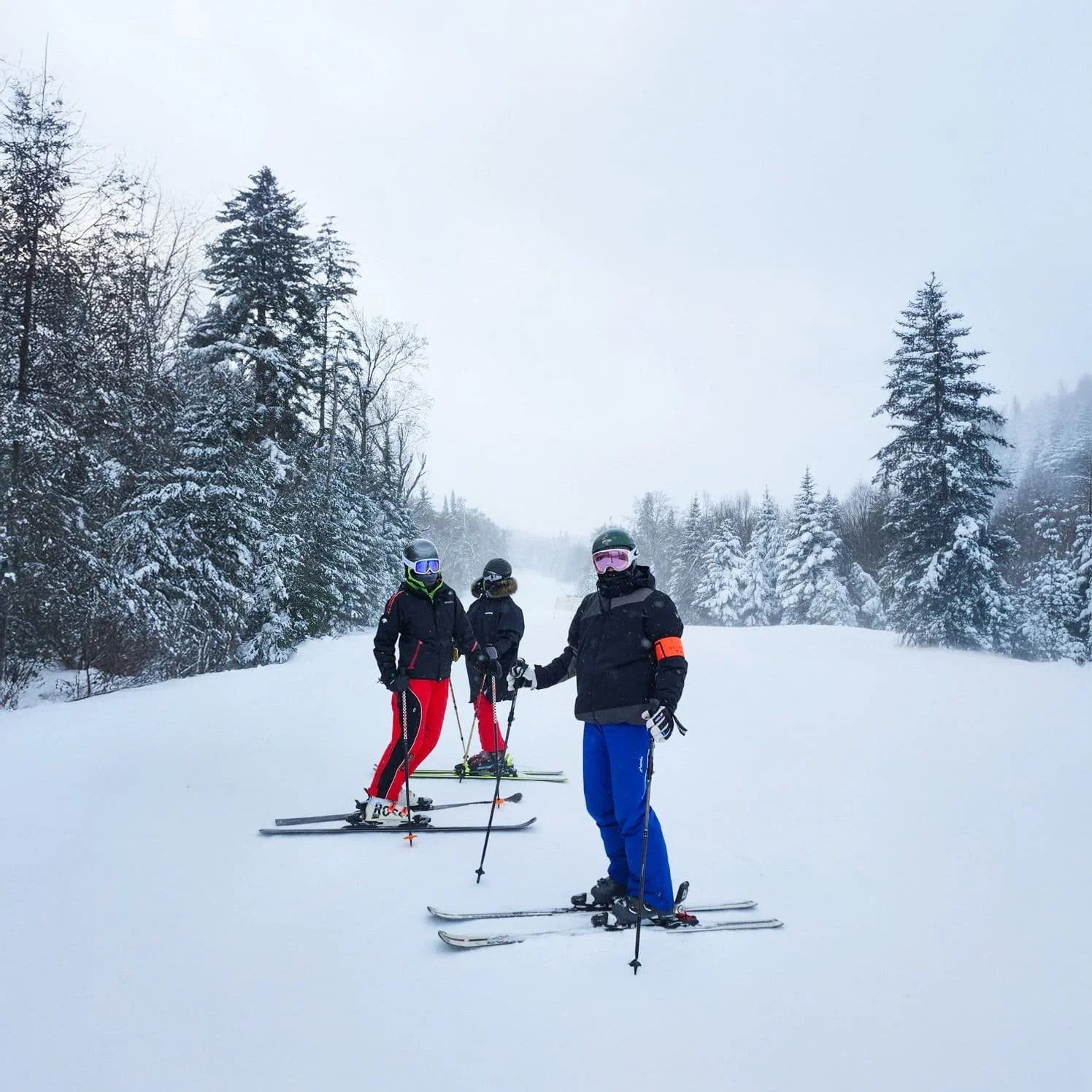 three skiers on a snowy ski trial