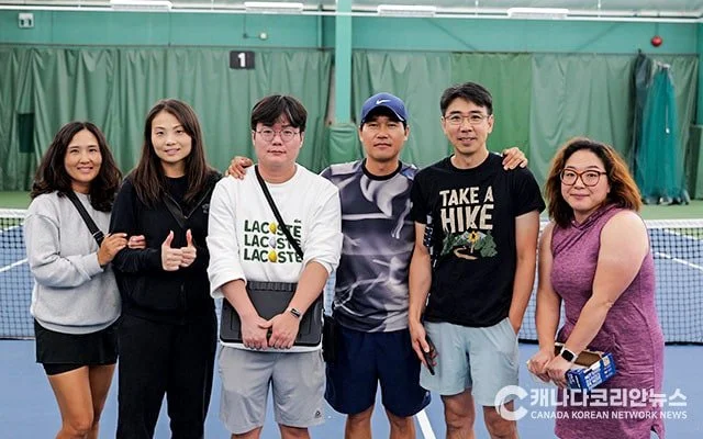 group of beginner tennis players looking at the camera after a tennis lesson